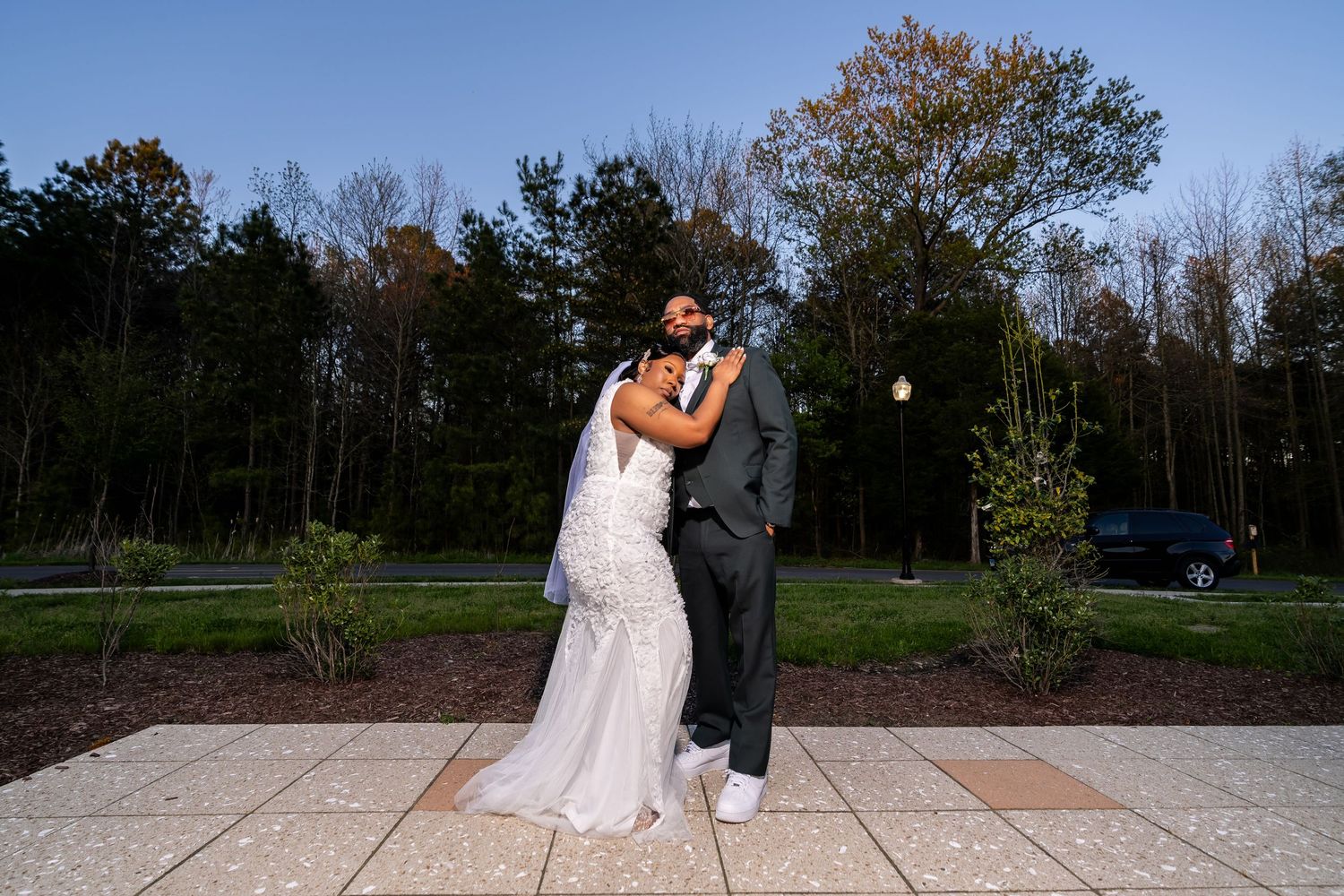 A couple in wedding attire embraces outdoors in a romantic photoshoot across multiple scenic locations.