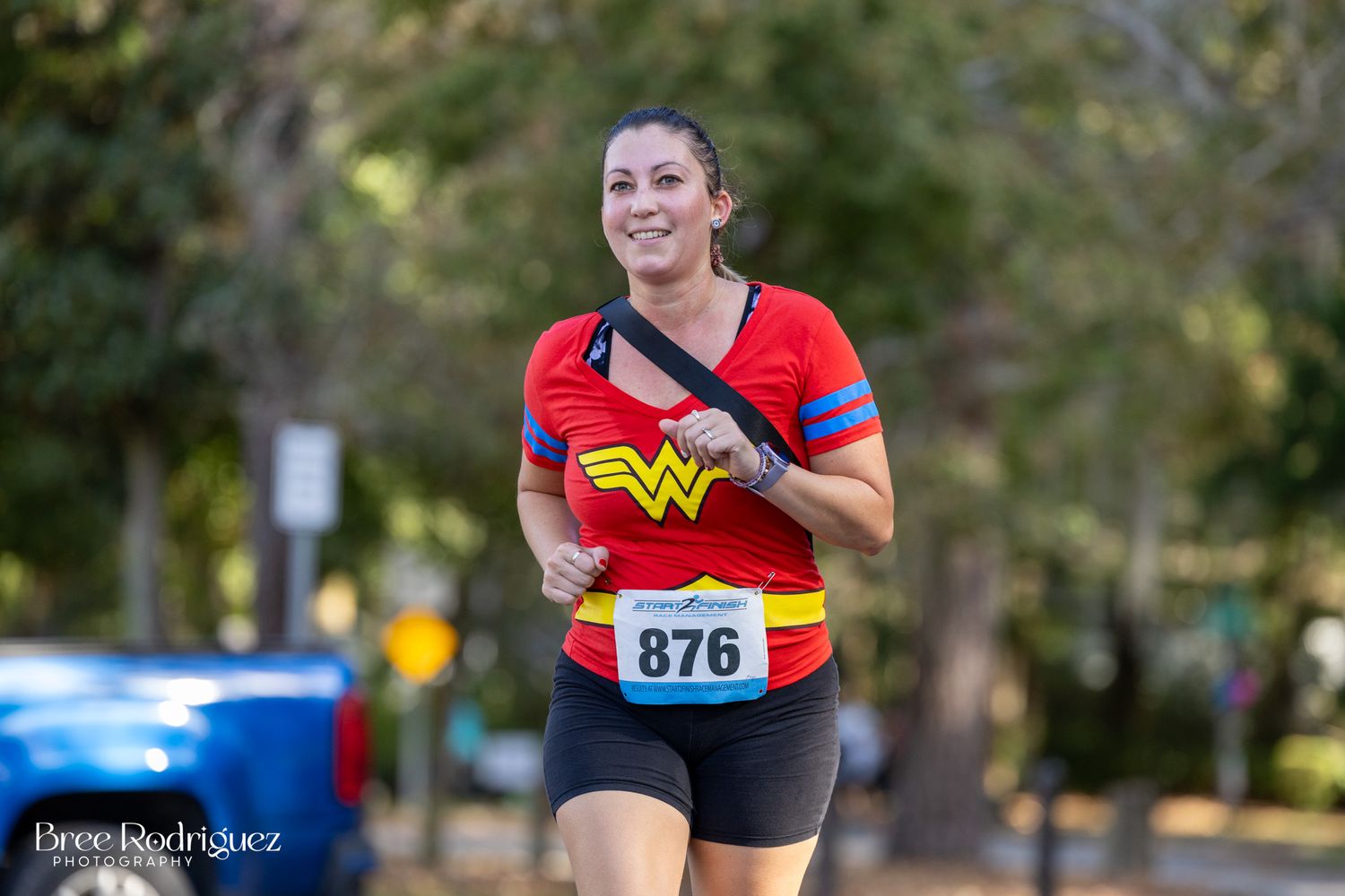 Photo of a women wearing a red wonder woman tshirt and black shorts while running