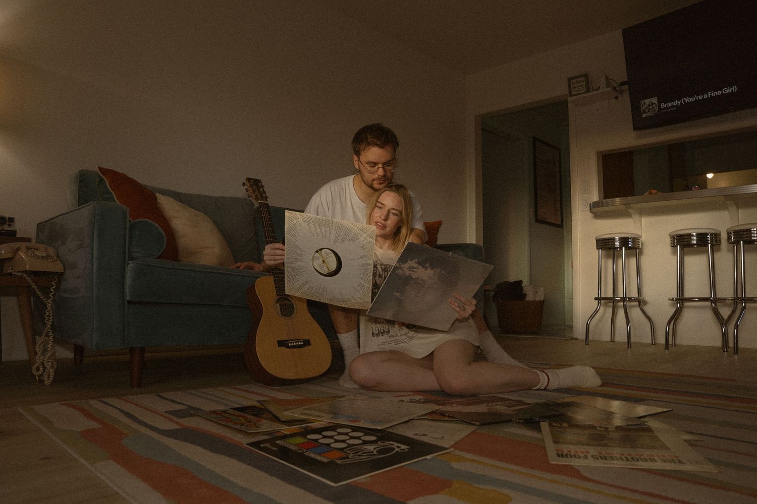 Cozy indoor scene with guitar and warm lighting creating intimate atmosphere.