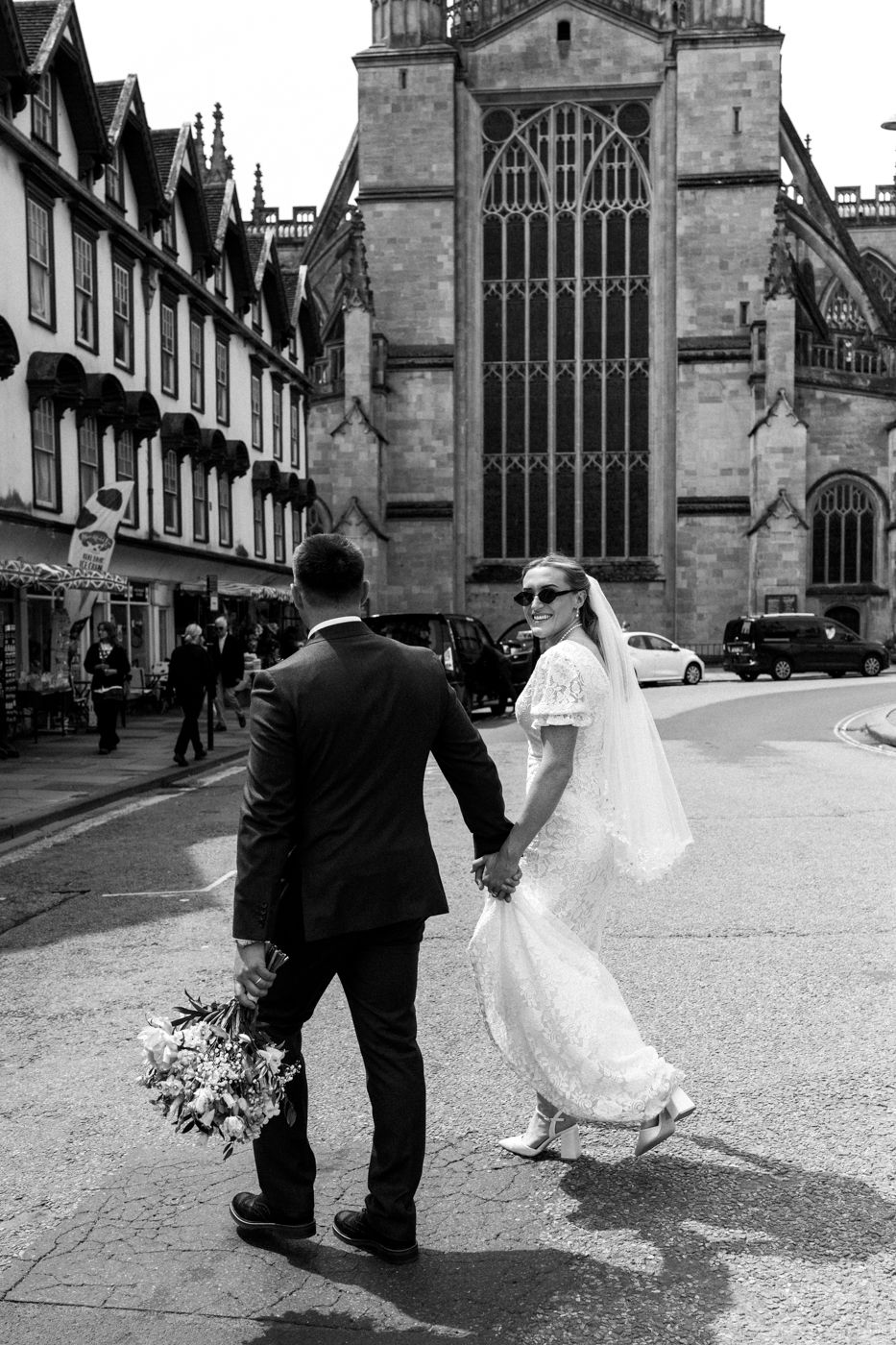 A romantic black and white wedding photo sequence showing four progressive dance dip moments outside of a historic church.