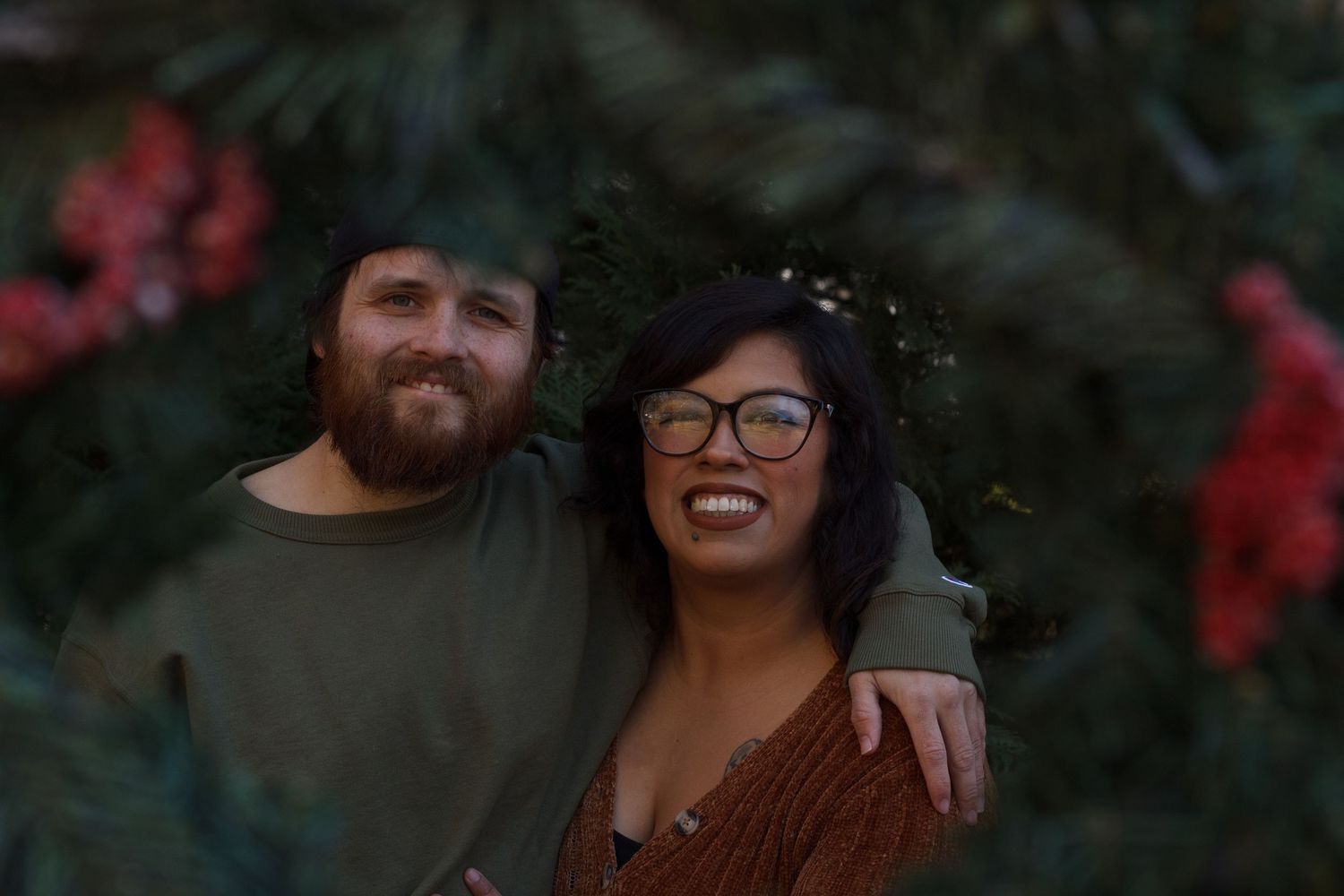 Couple smiling in cozy winter outfits surrounded by evergreens – Chattanooga TN Family photography.