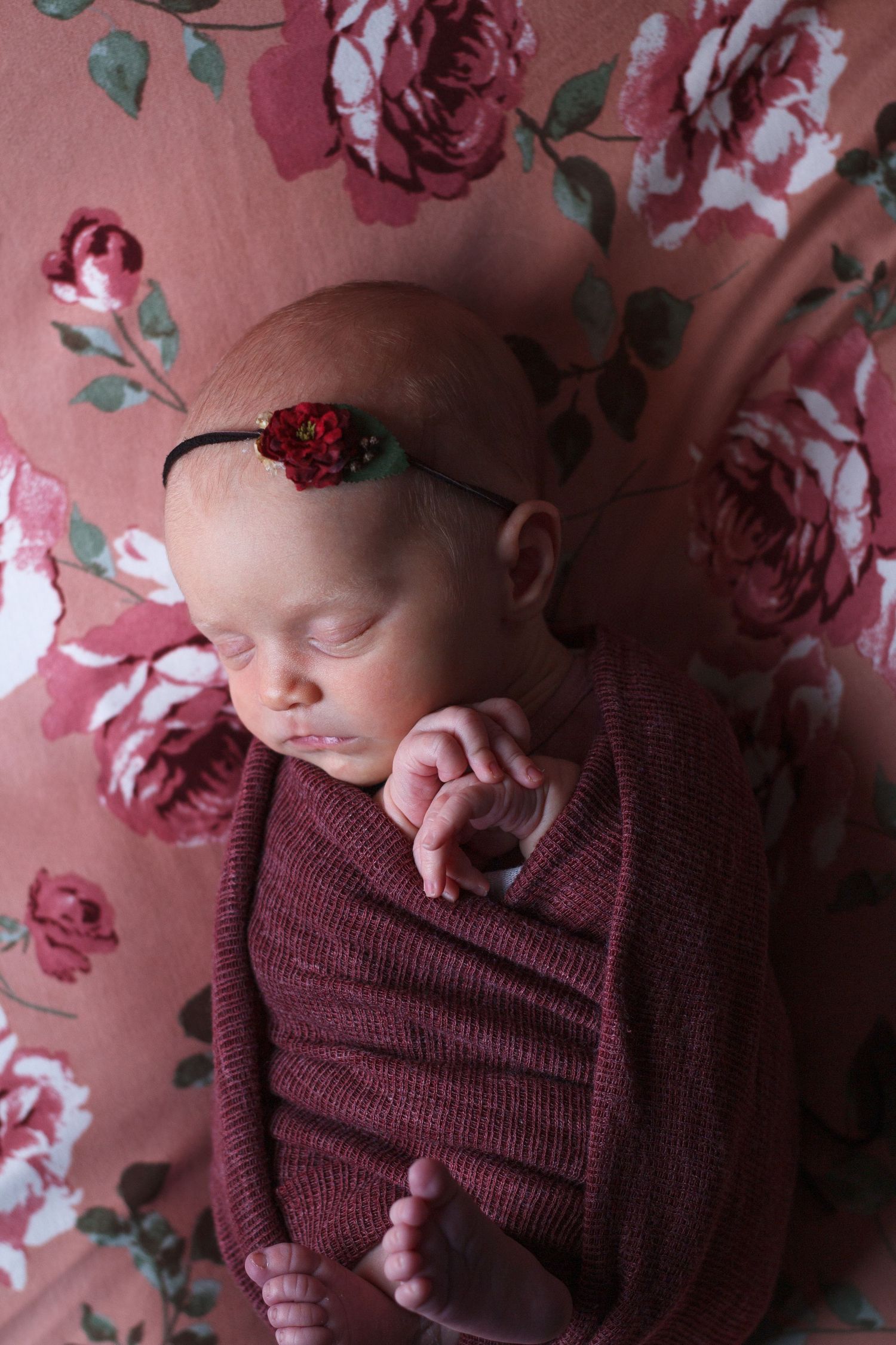 Swaddled newborn girl on floral backdrop – newborn photography in Chatsworth GA.