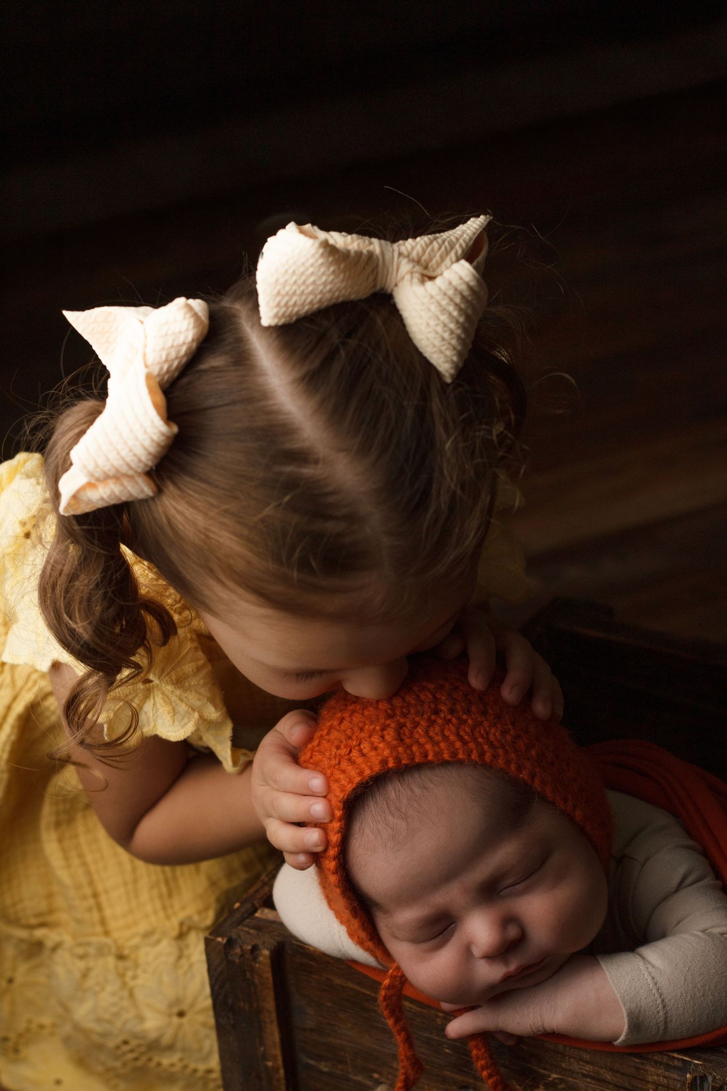 Young sibling gently holding a newborn baby during a family newborn photography session in Dalton, Georgia.