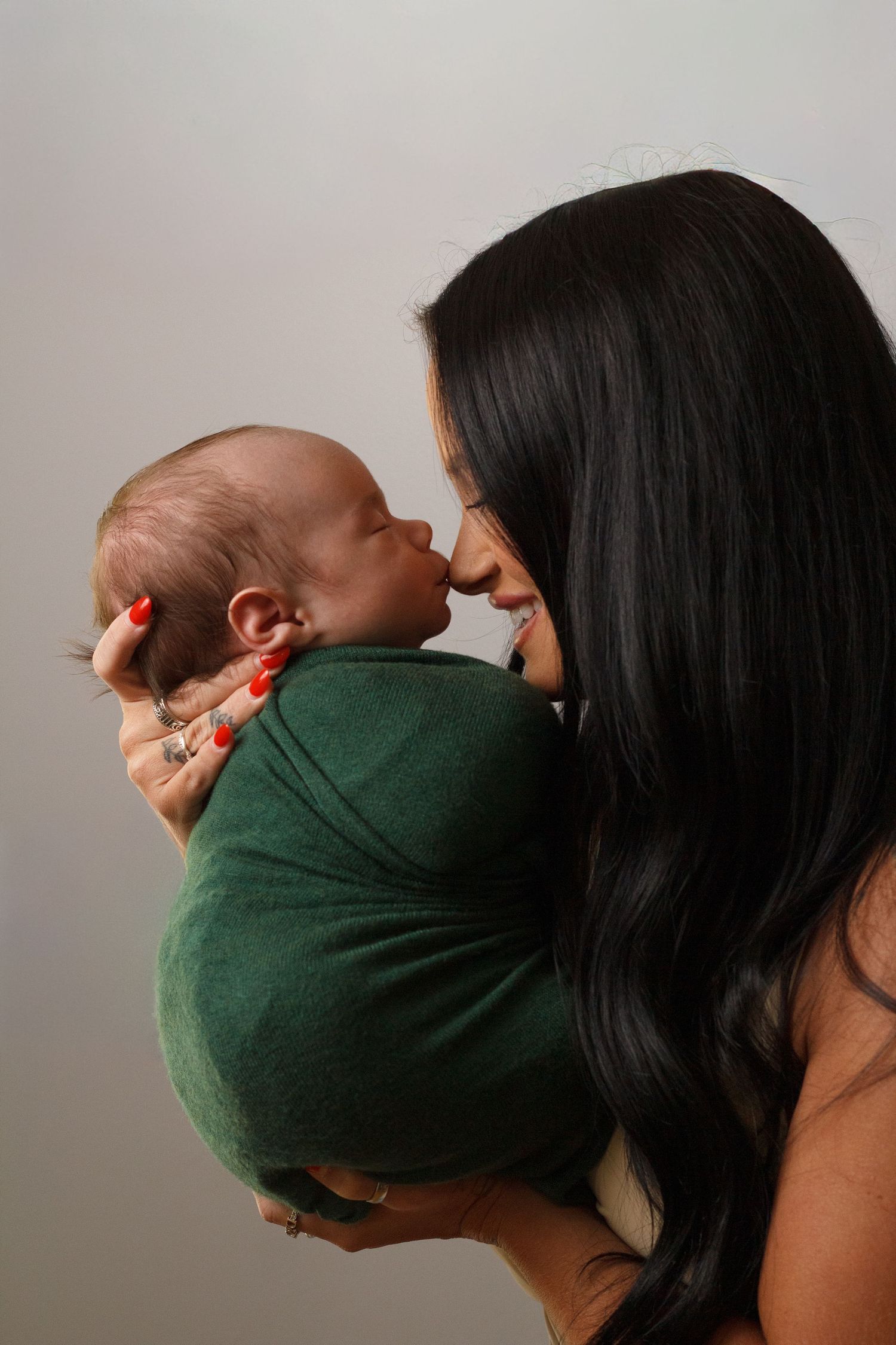 Mother holding her newborn baby during a natural and intimate newborn photography session in Dalton, Georgia.