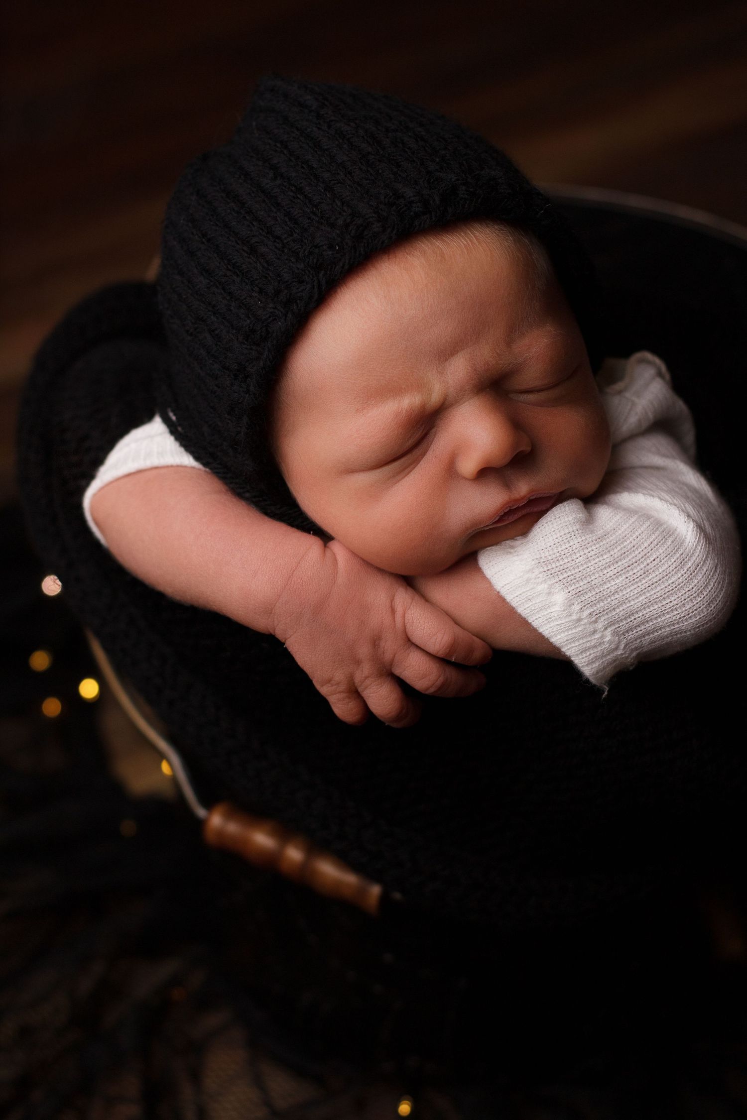 Newborn baby boy in a bucket resting his chin on his hands during a Dalton Georgia Newborn session