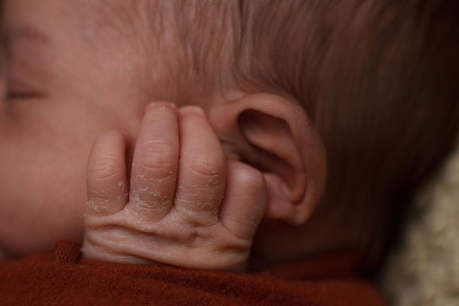 Close-up detail of a newborn baby’s ear and tiny fingers during a newborn photography session in Dalton, Georgia.
