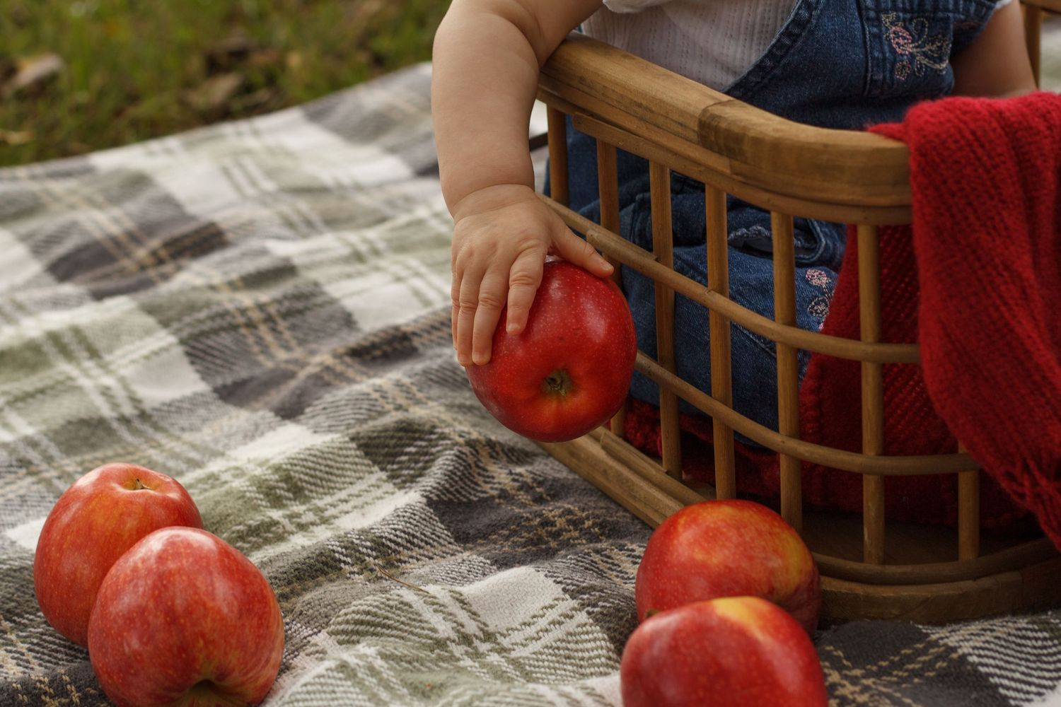 Baby's little hand holing a red apple during a milestone session in Tunnel Hill Georgia.