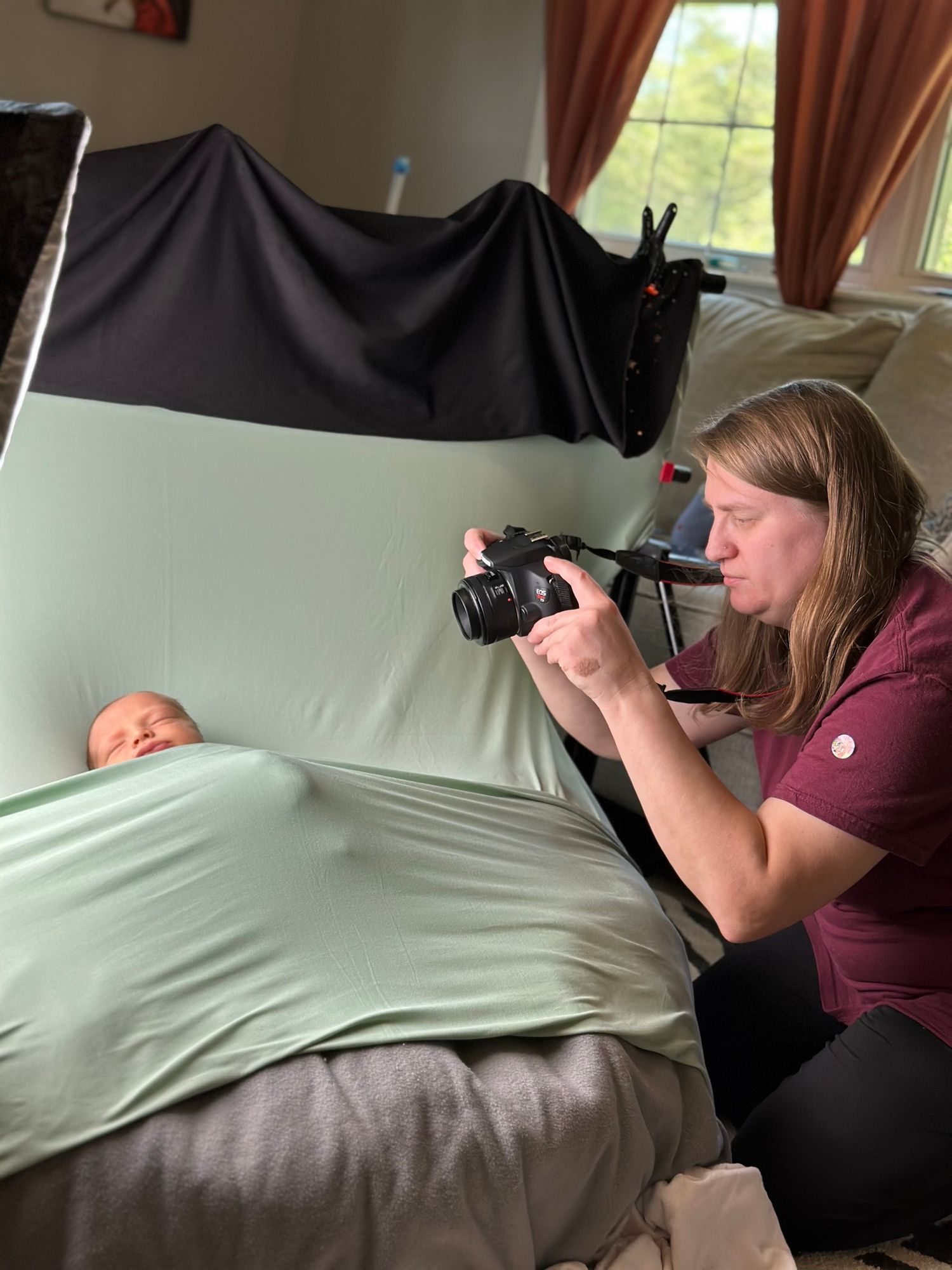 Dalton, GA newborn and family photographer Tiffany taking a photo of a newborn during a cozy in-home session.