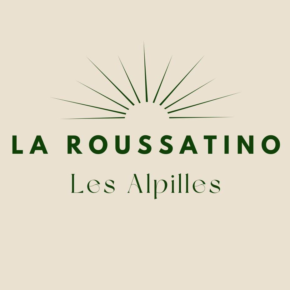 Logo of La Roussatino Les Alpilles featuring dark green text and a sunburst design on a beige background.