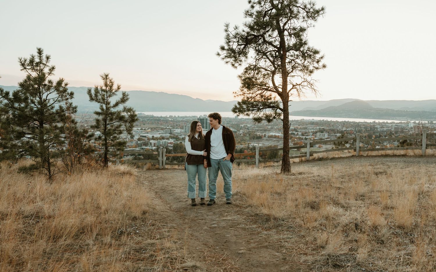 natural couples photo session in kelowna bc walking together in grassy field