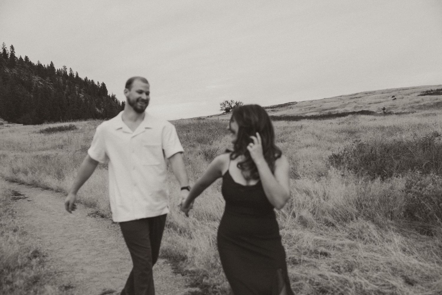 candid photo of couple running and playing at kalamalka lake in Vernon bc