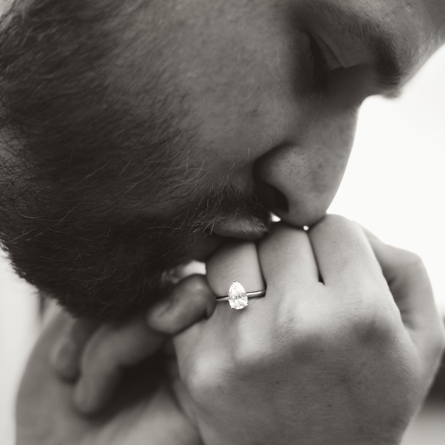 image of man kissing and admiring engagement ring in kalamoir regional park bc