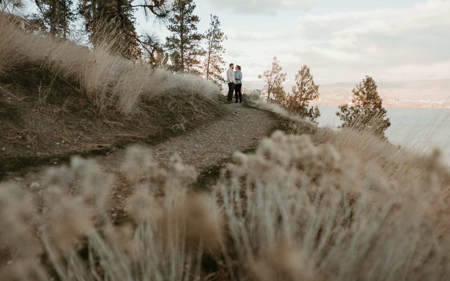 natural engagement photography In the okanagan capturing a couple walking together on the beautiful mountain side