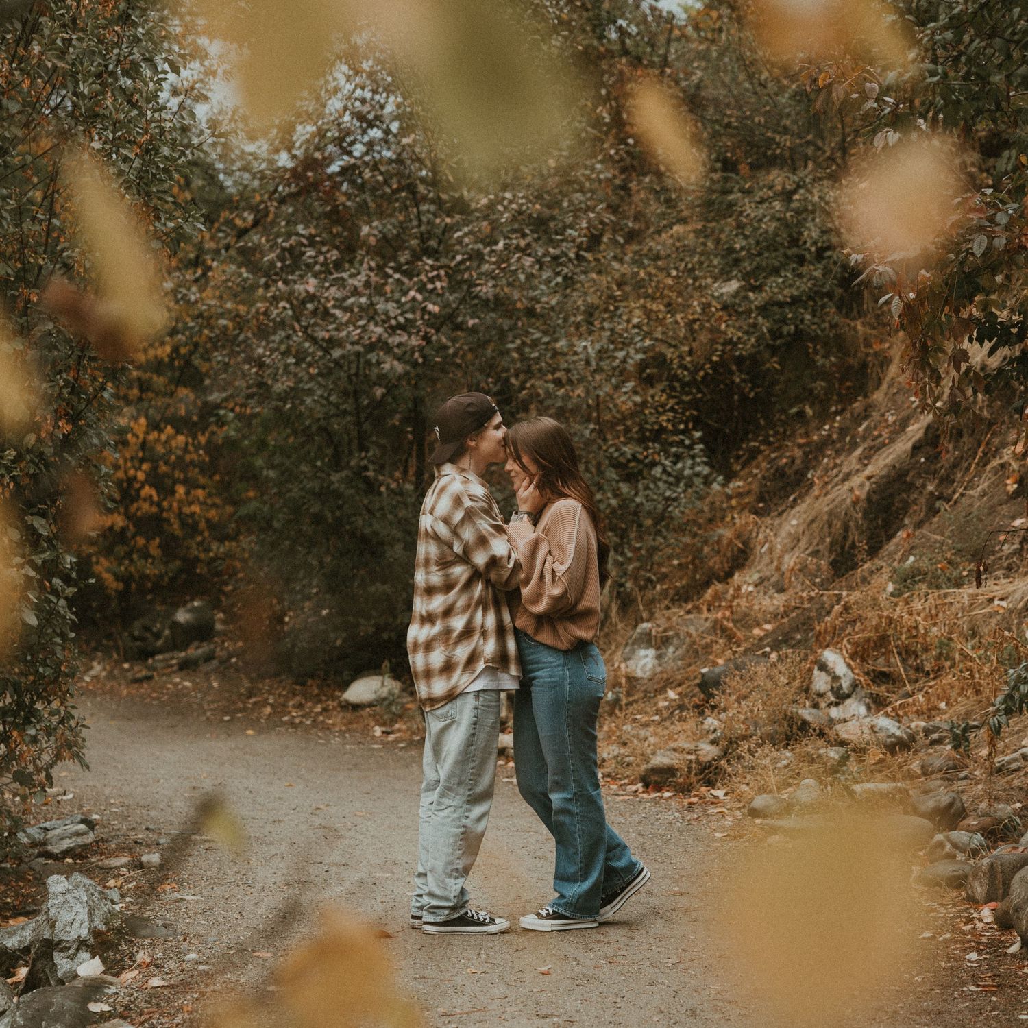 Kelowna couples session with beautiful yellow fall leaves in the foreground