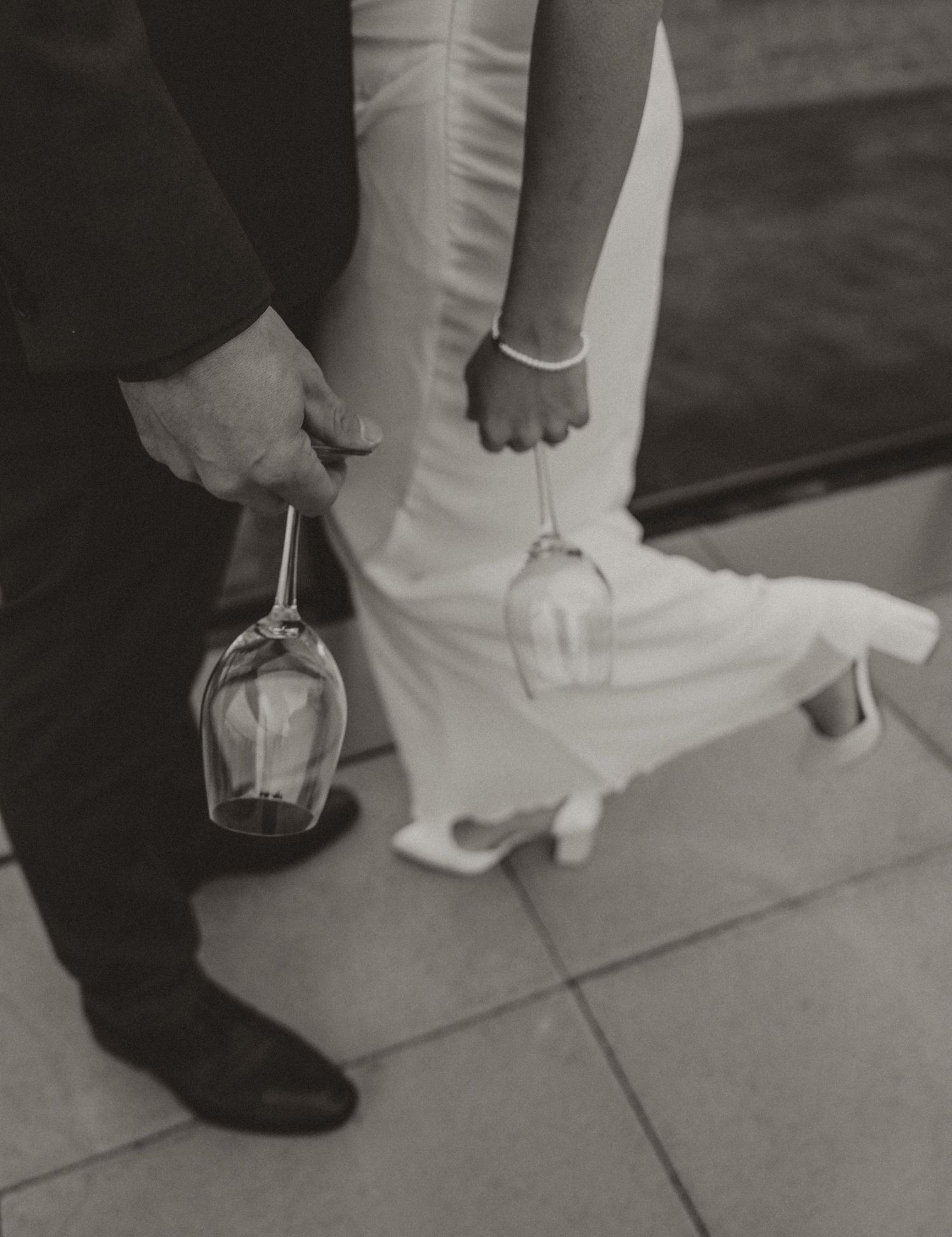 intimate image of couple holding wine glasses at kelowna winery during their elopement