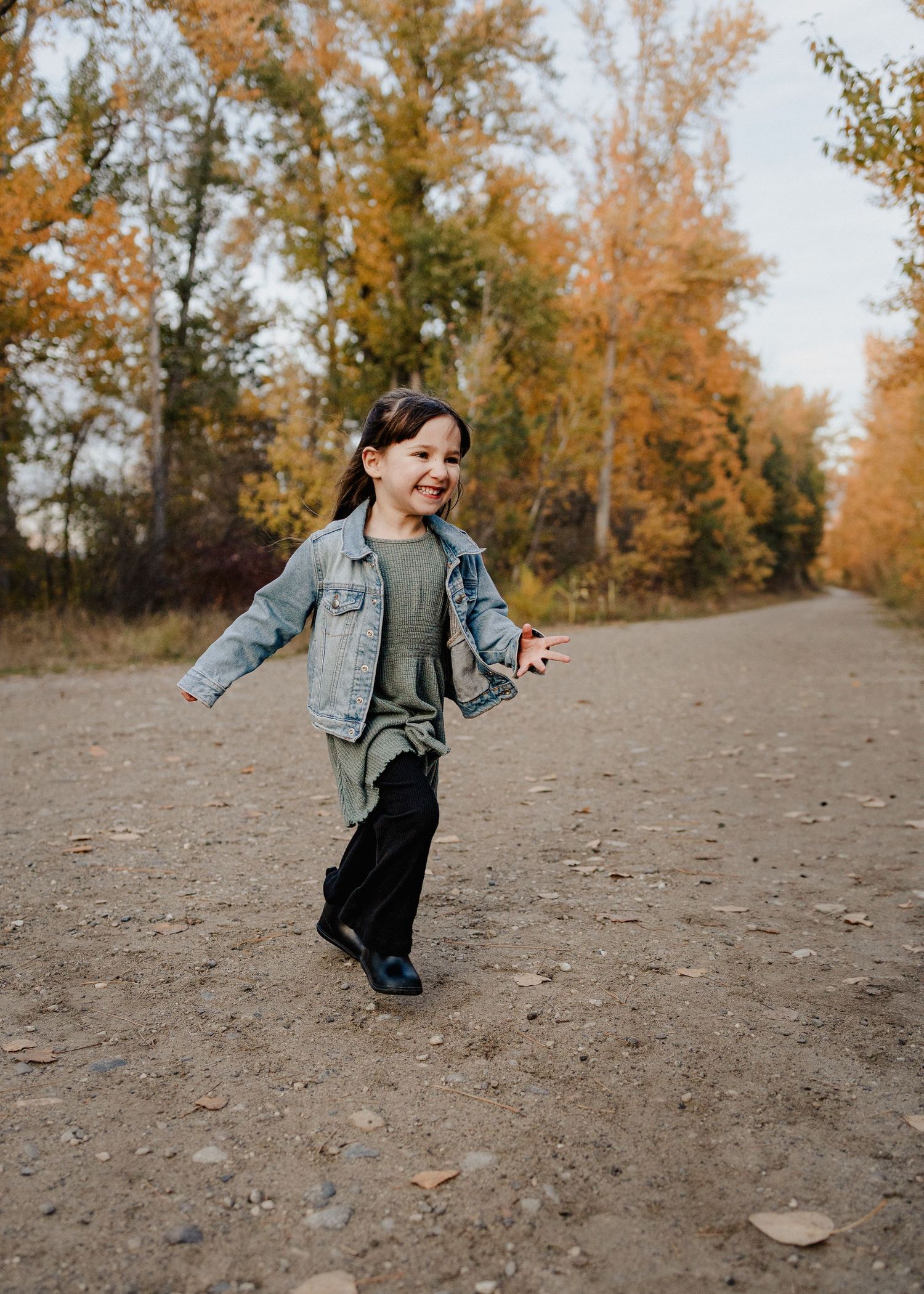 child smiling and laughing at a family photoshoot in kelowna bc along missions creek greenway
