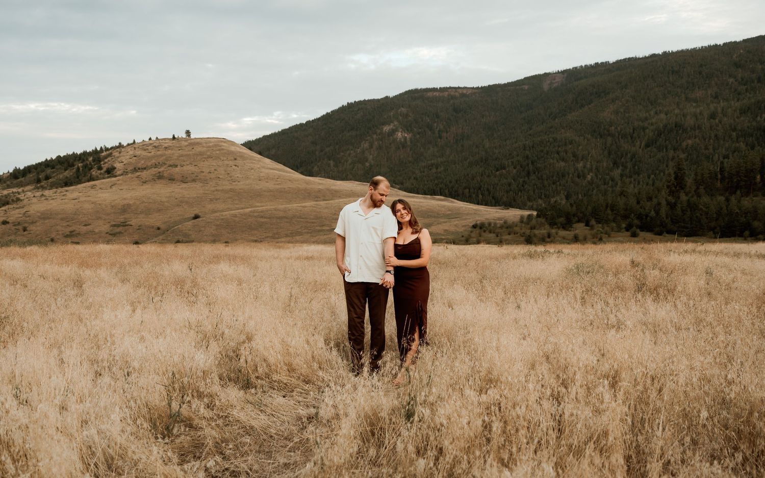 photo of couple standing in field during photo session in Vernon bc