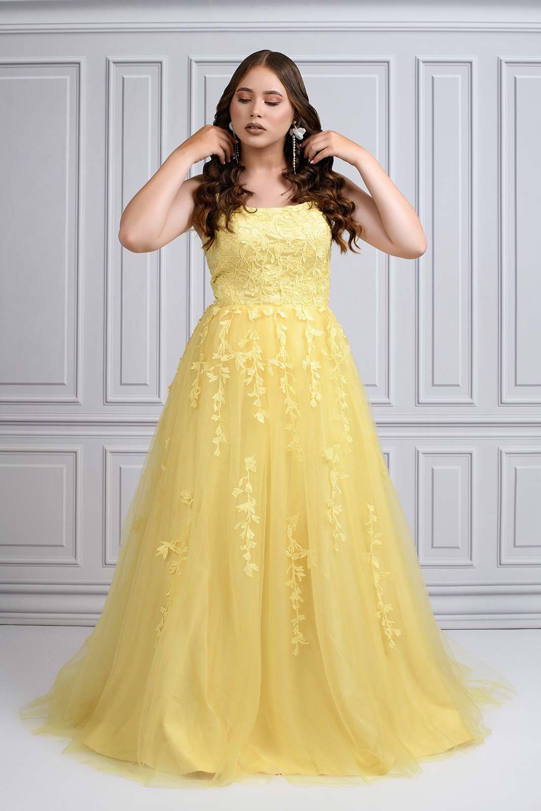 Yellow tulle ball gown with delicate lace details features a strapless neckline and full floor-length skirt.