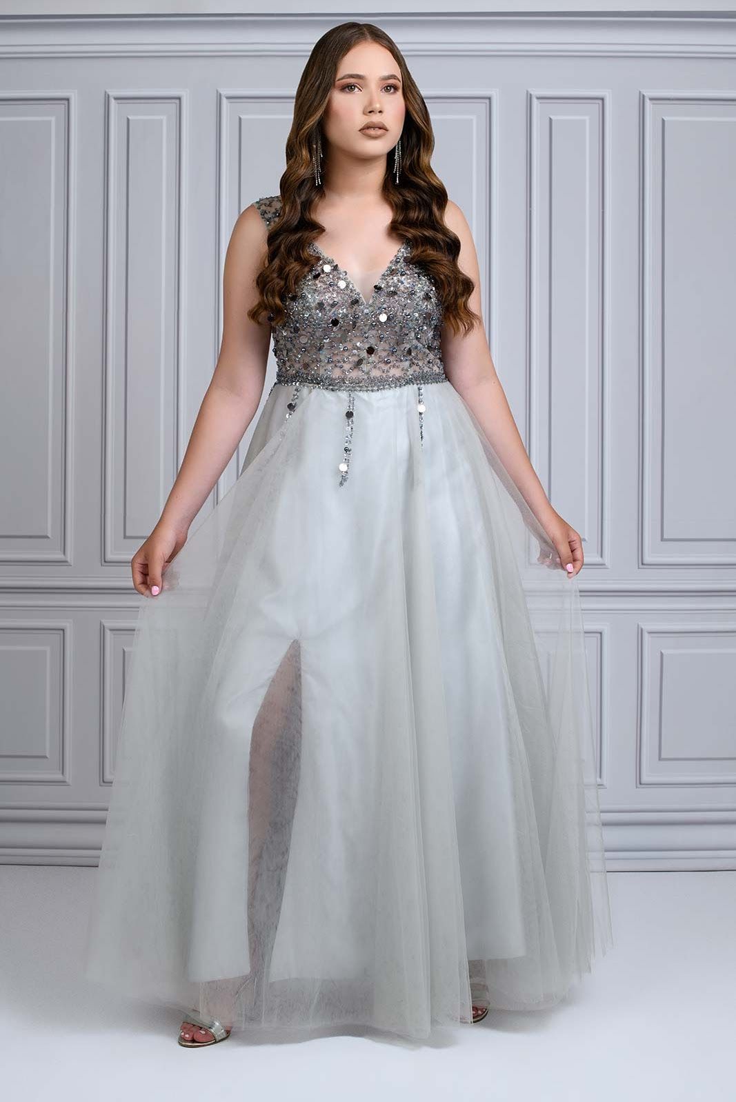 Silver beaded bodice white tulle gown with full skirt and v-neckline in formal studio setting.