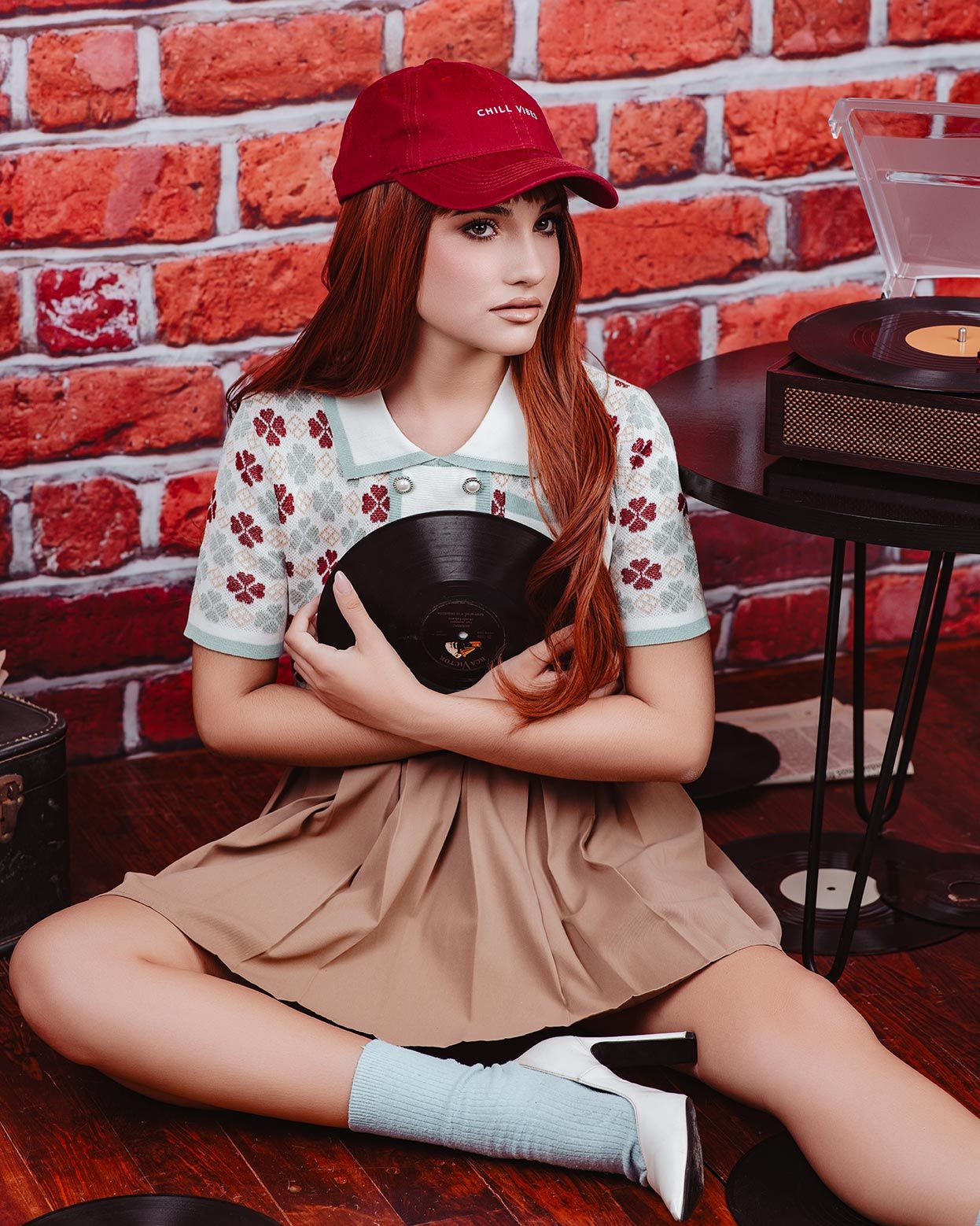 Vintage-style photo with vinyl records against red brick wall featuring retro fashion and nostalgic accessories.