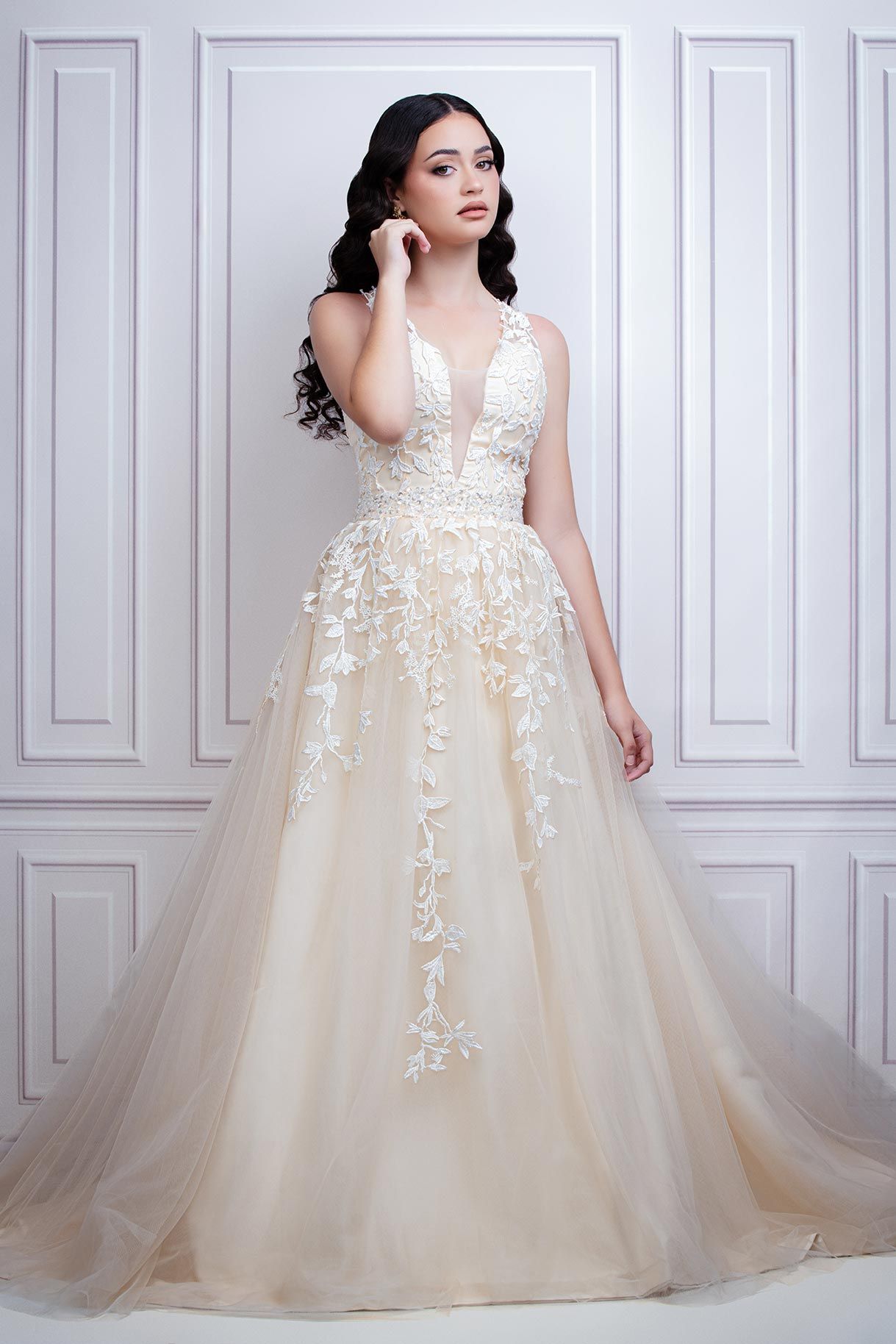 A stunning champagne tulle wedding gown with delicate lace appliques and a plunging neckline.