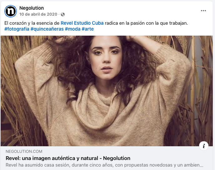 Artistic portrait of someone with curly hair wearing neutral tones against a natural reed backdrop.