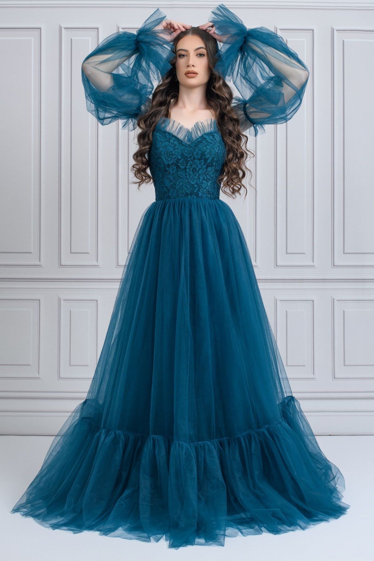 Teal tulle evening gown featuring dramatic puff sleeves and fitted bodice with full skirt.