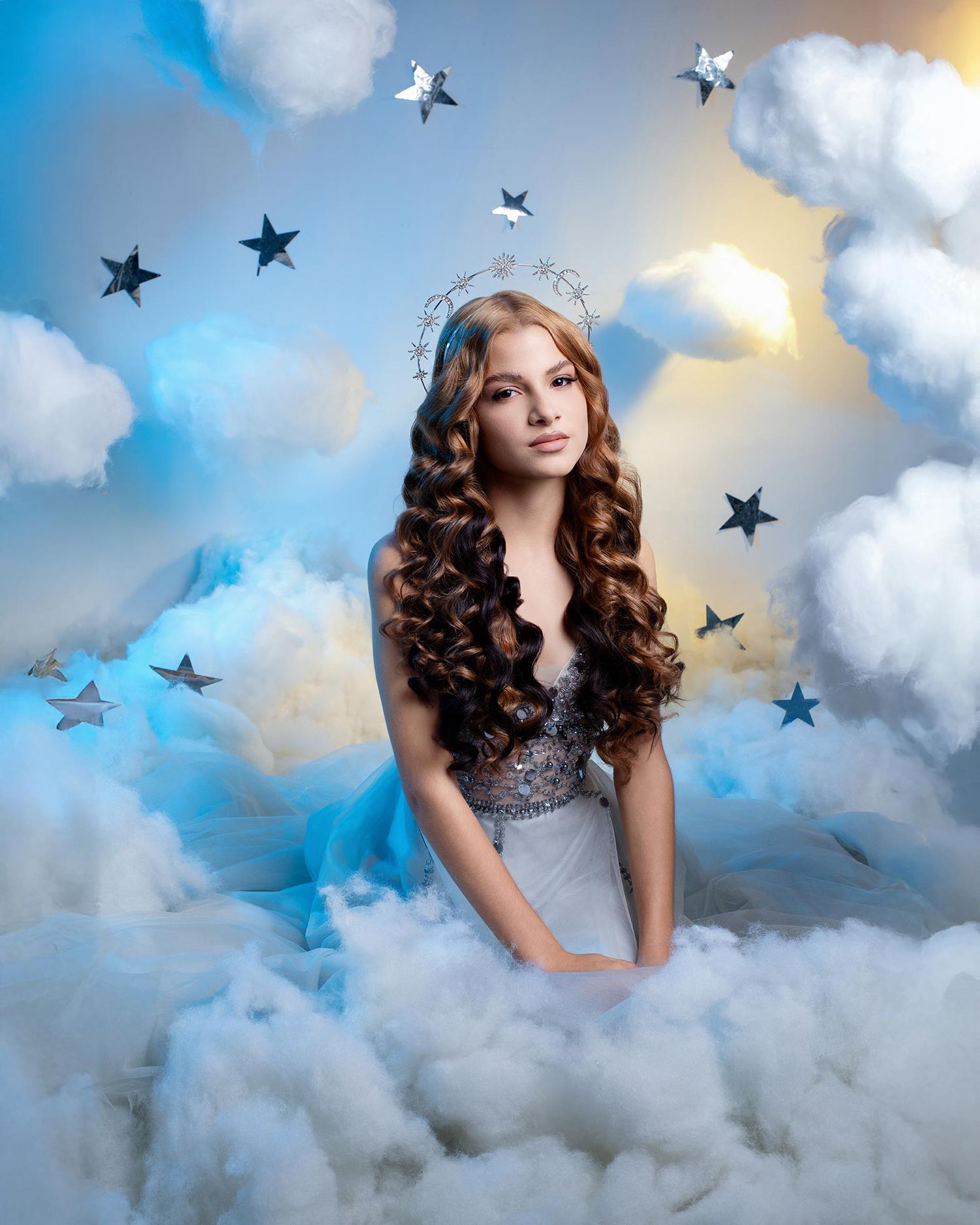 A whimsical portrait featuring long curls and a silver tiara amid clouds and decorative stars in a dreamy sky setting.