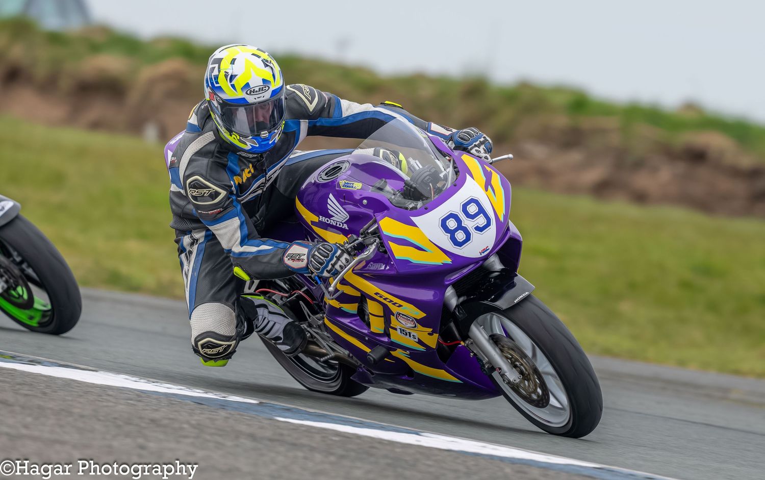 A purple and yellow motorbike number 89 negotiates a corner