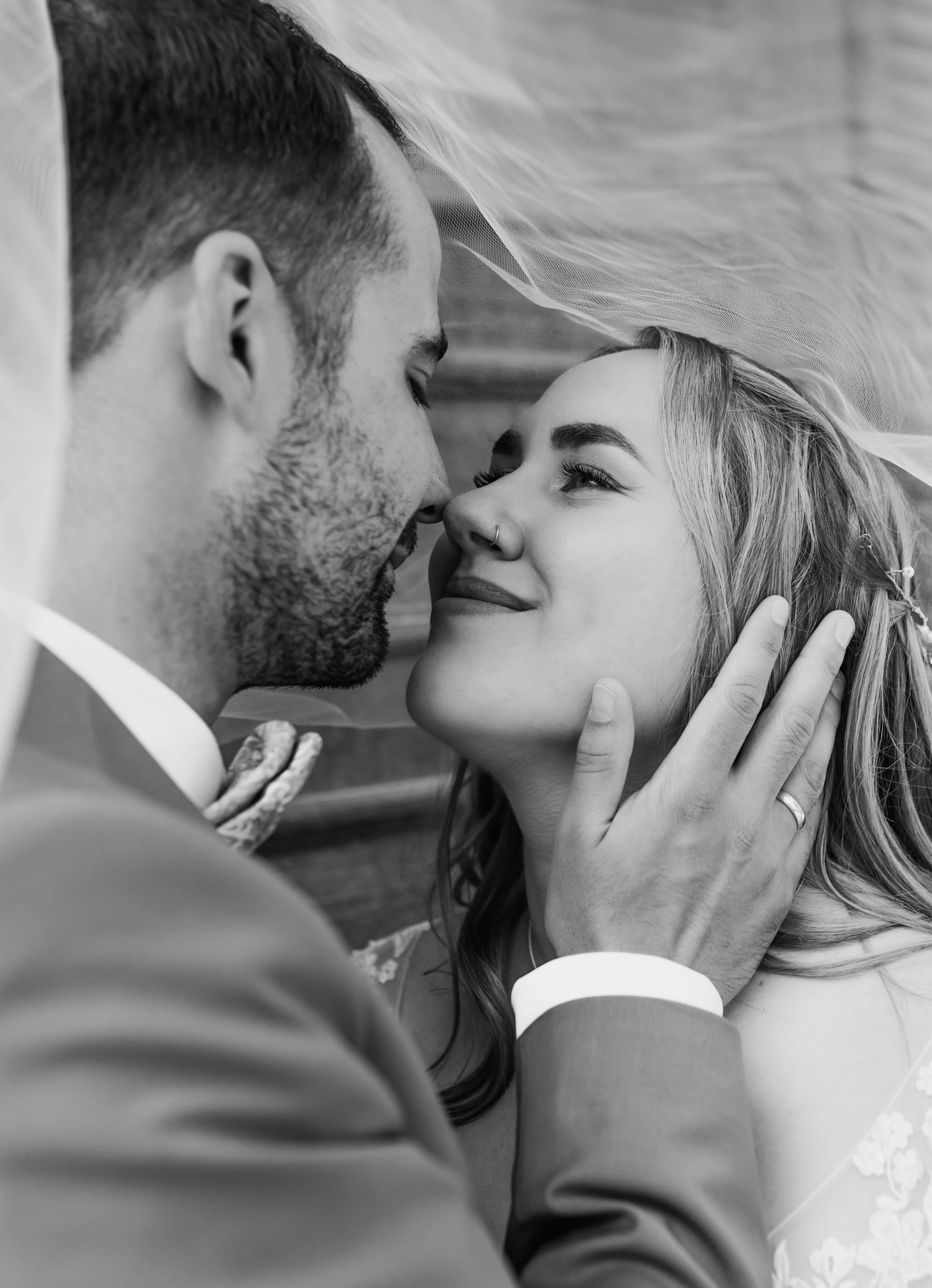 Romantic close-up of newlyweds sharing an intimate moment in black and white.