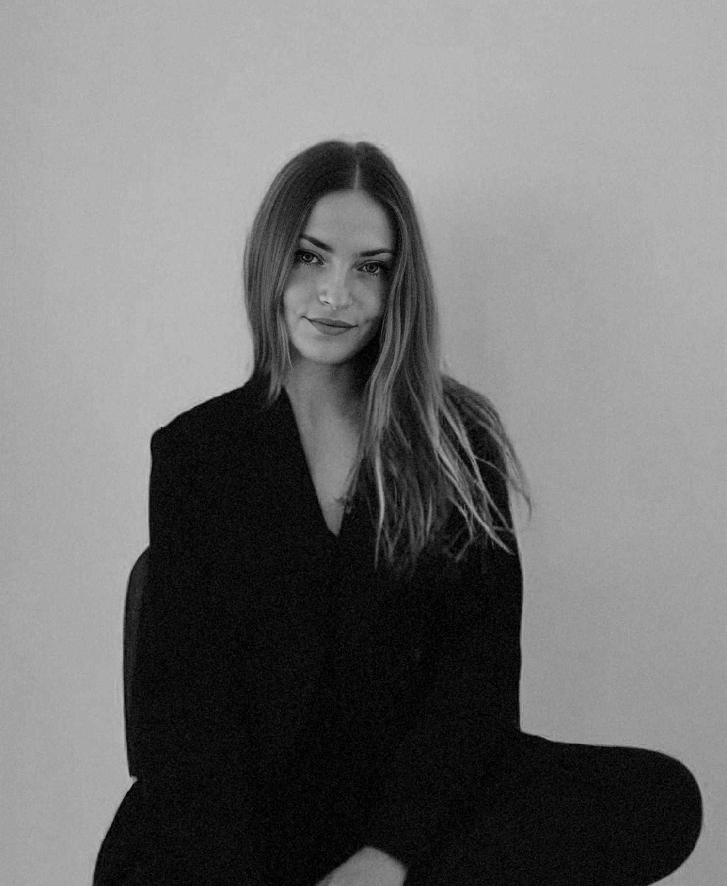 A black and white portrait series showing different dramatic poses with a minimalist background and dark clothing.