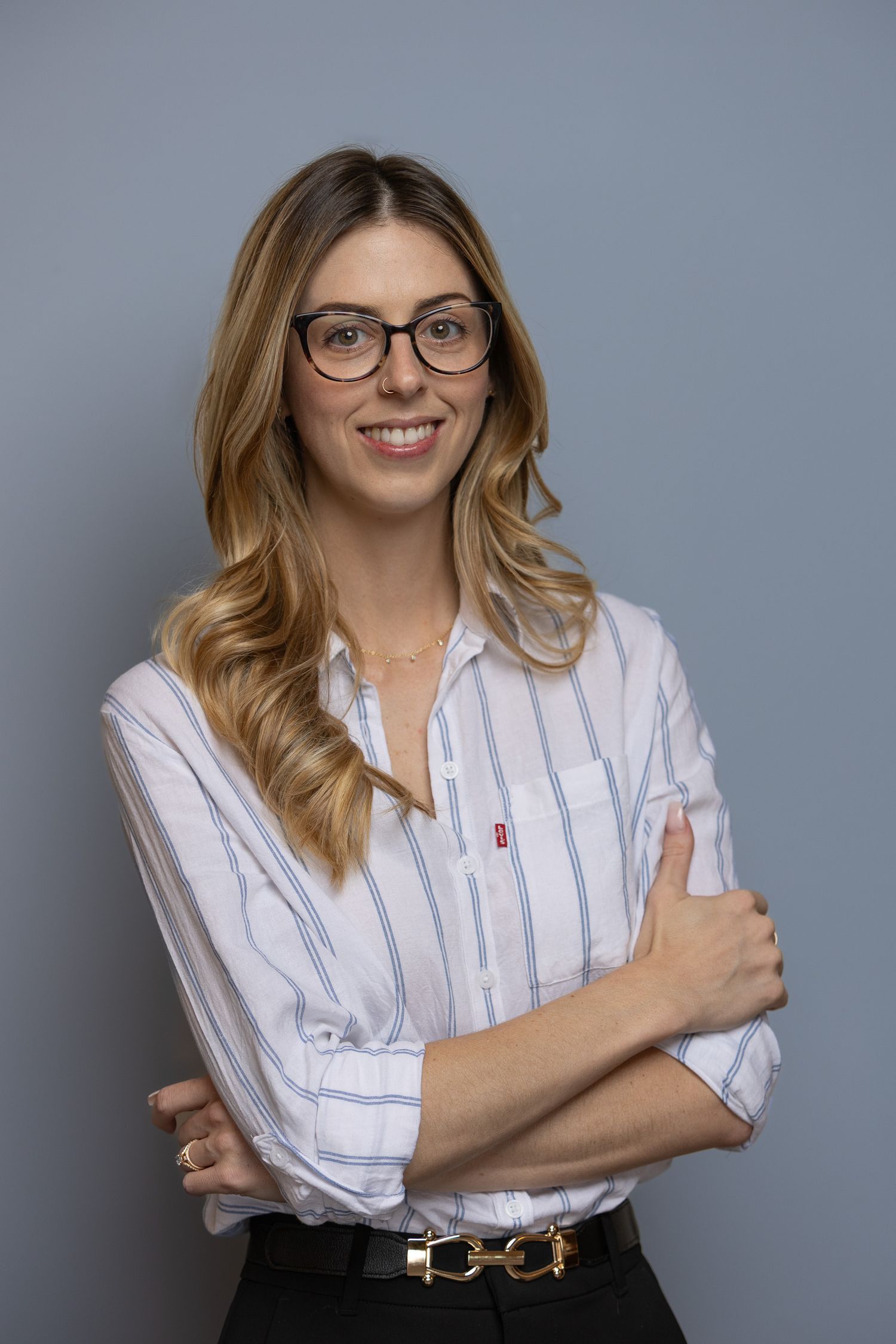 Professional portrait series of a person in a white striped button-down shirt and glasses against a gray background.