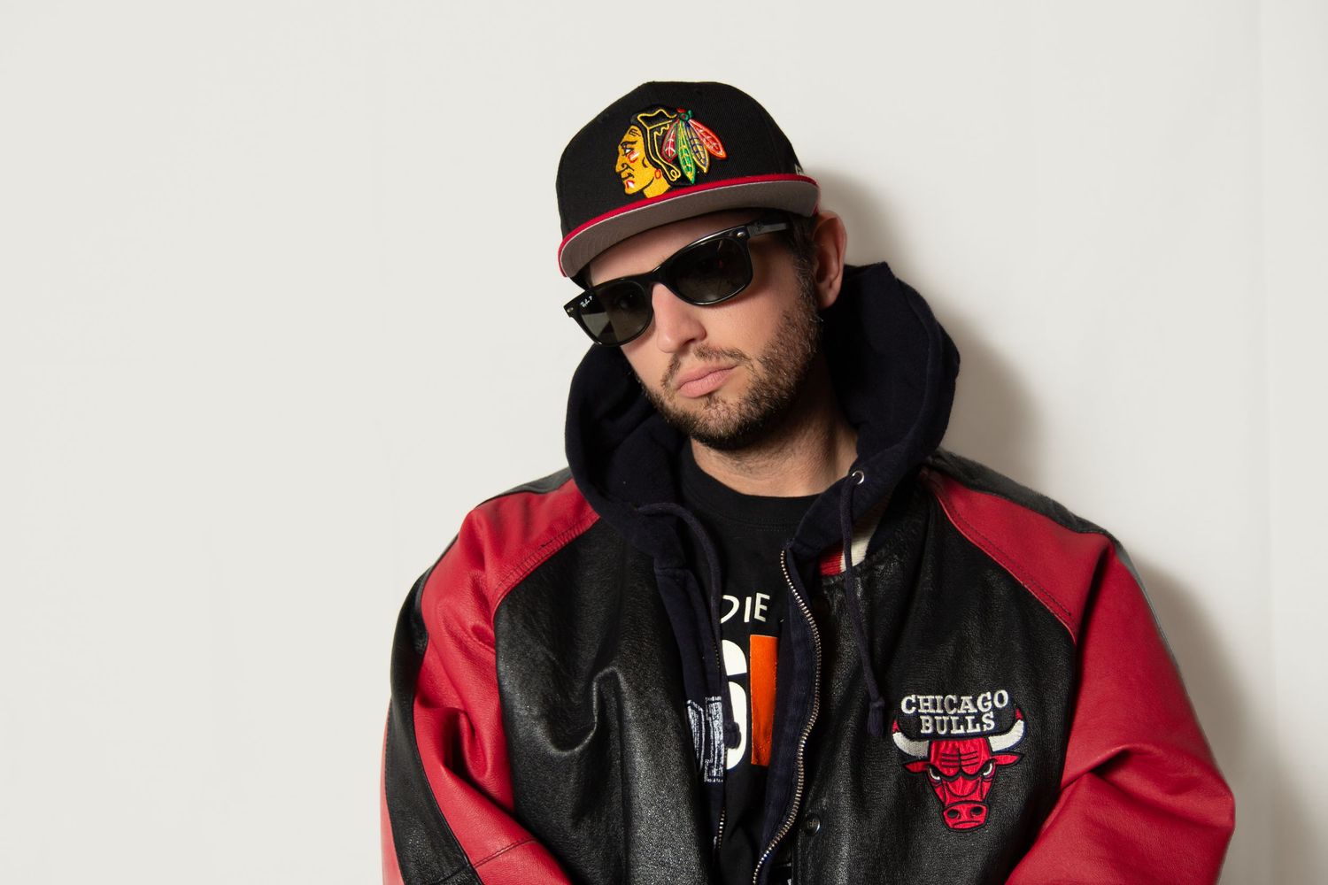 Person wearing Chicago Bulls jacket and cap against white background.
