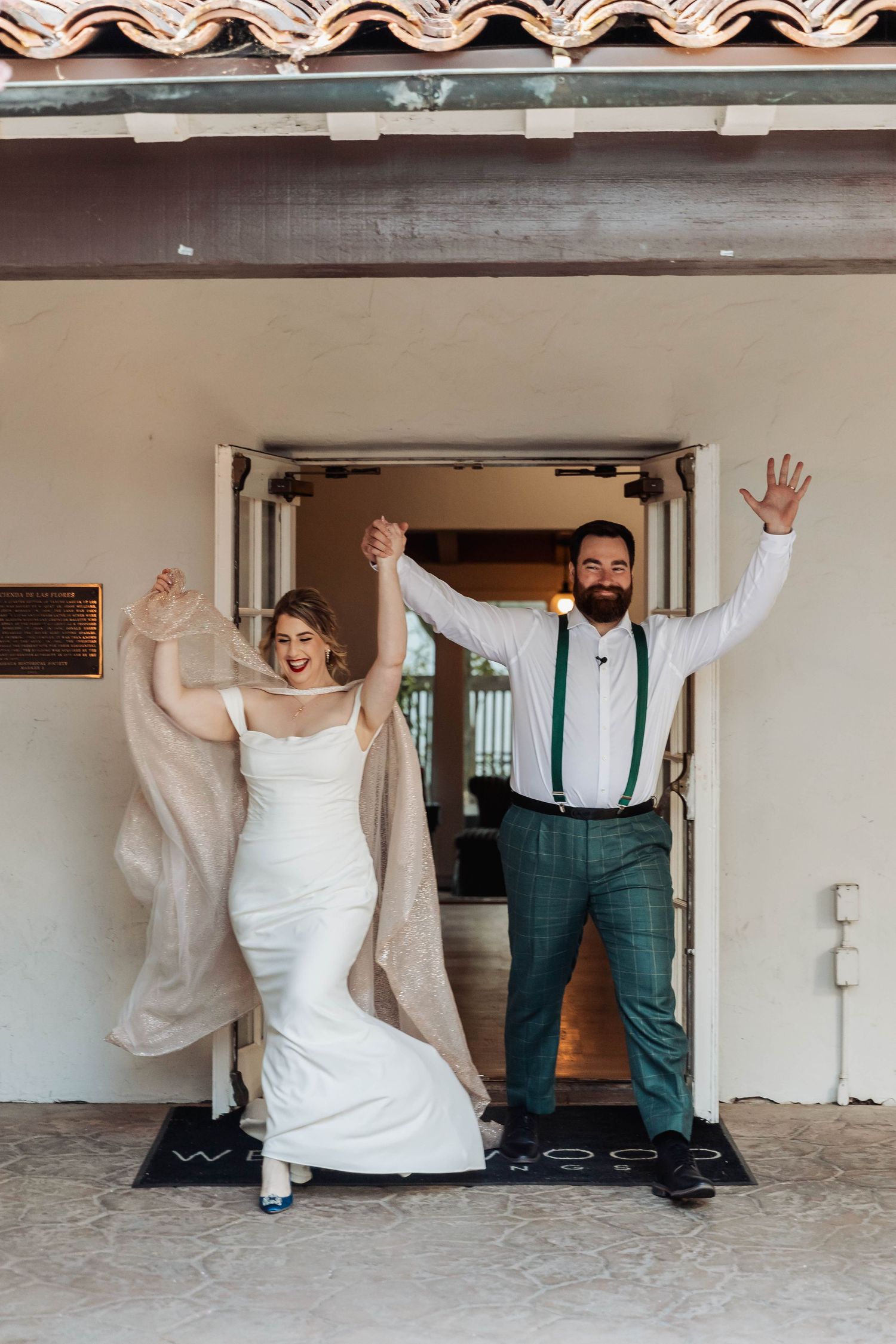 Celebratory moment captured in front of doorway showing joyful expressions and raised arms.