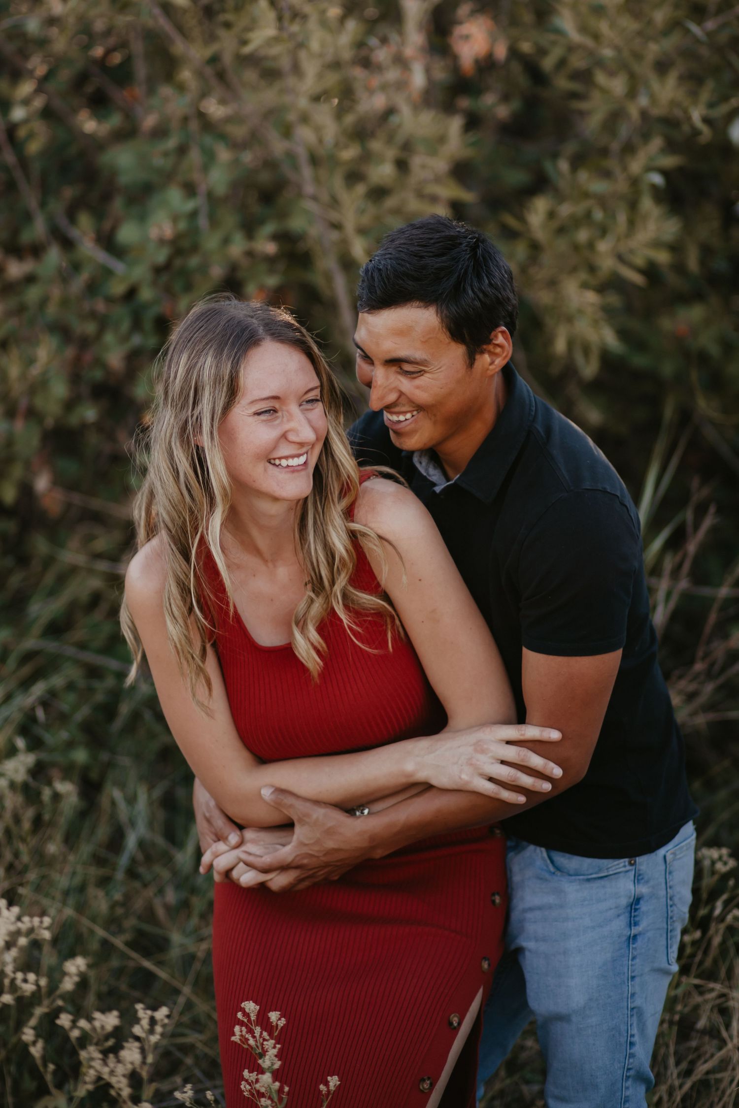 A couple embraces and laughs together during their outdoor portrait session.