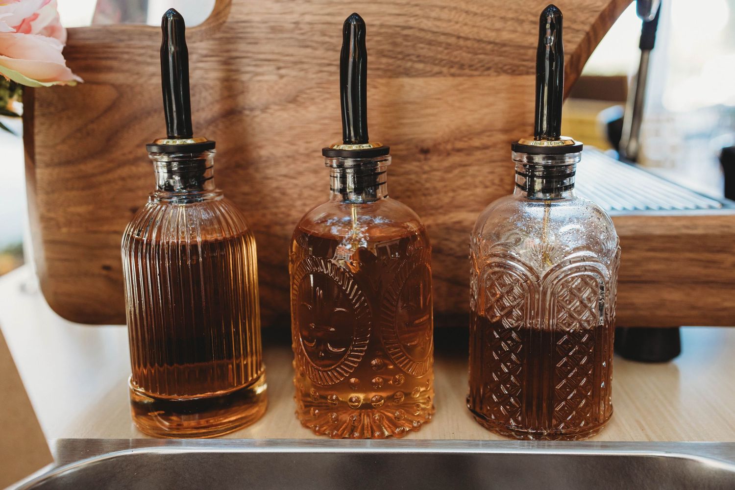 Row of vintage glass whiskey decanters displayed on wooden surface.