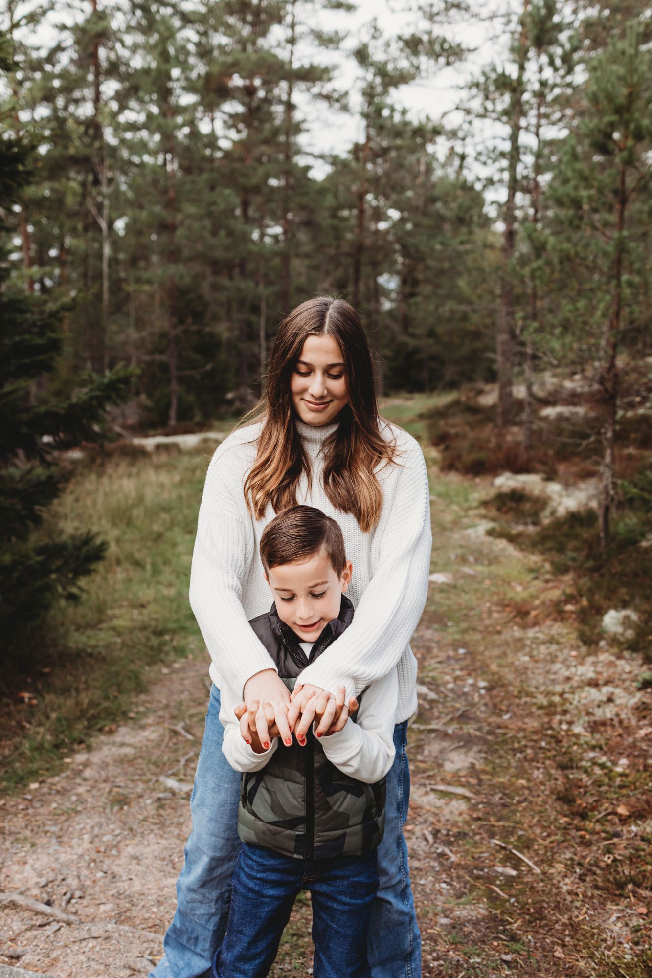 A tender moment between parent and child while exploring a forest path.
