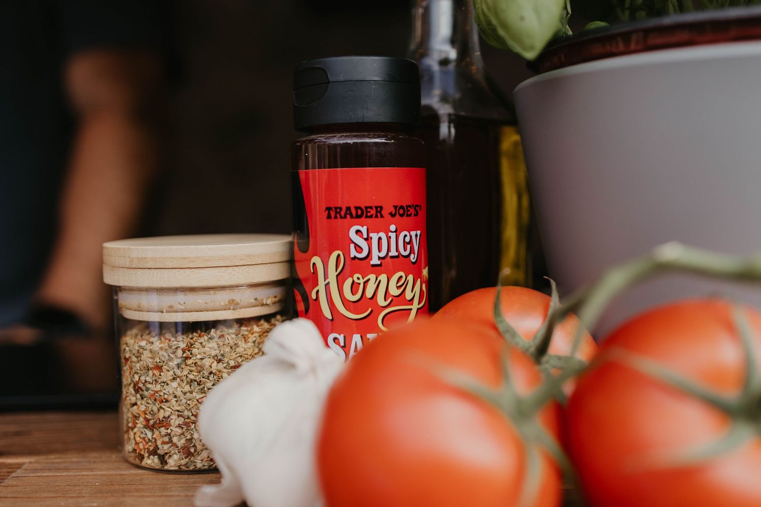Cooking ingredients including tomatoes, spices, and seasonings arranged on a kitchen counter.