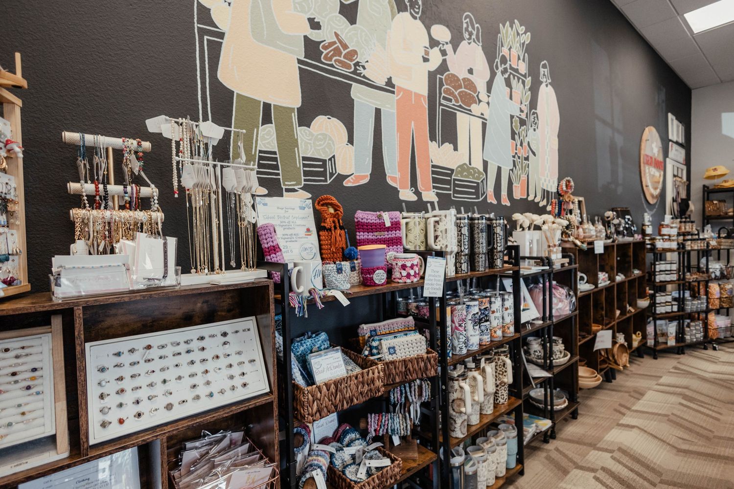 Long view of boutique interior with organized shelving units displaying jewelry and accessories.