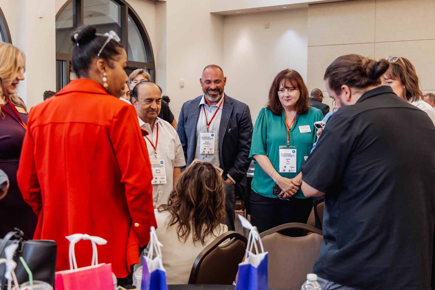 Group of conference attendees gathered in circle during networking session.