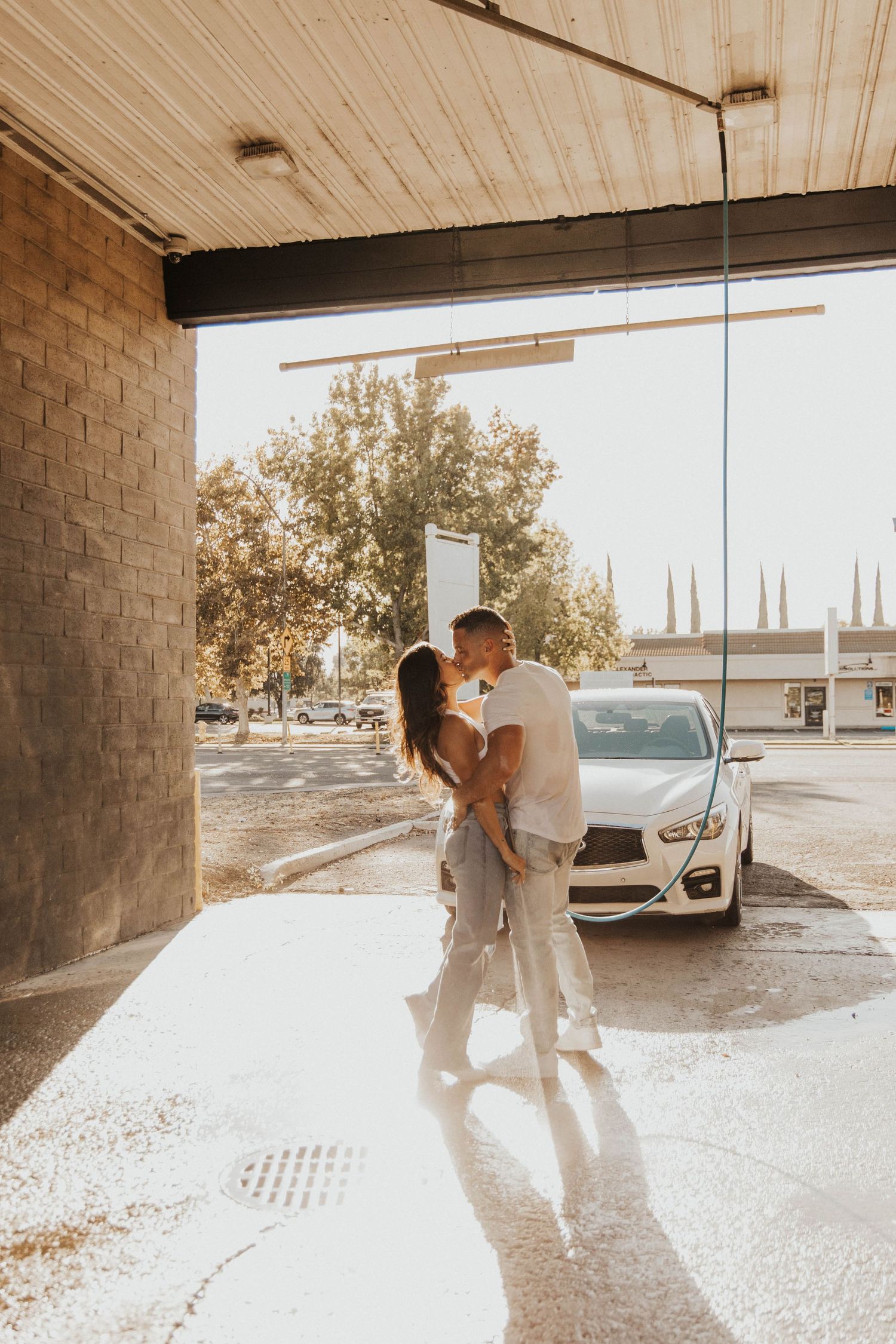 Sun-drenched couple photos under covered parking area.