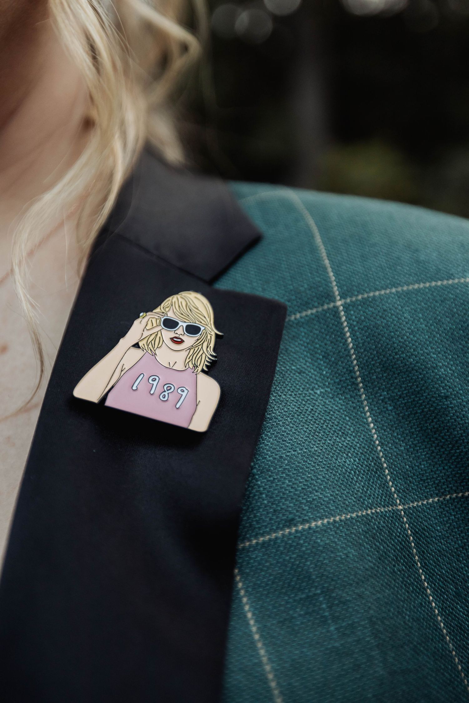Close-up detail of a decorative pin or brooch on dark fabric.