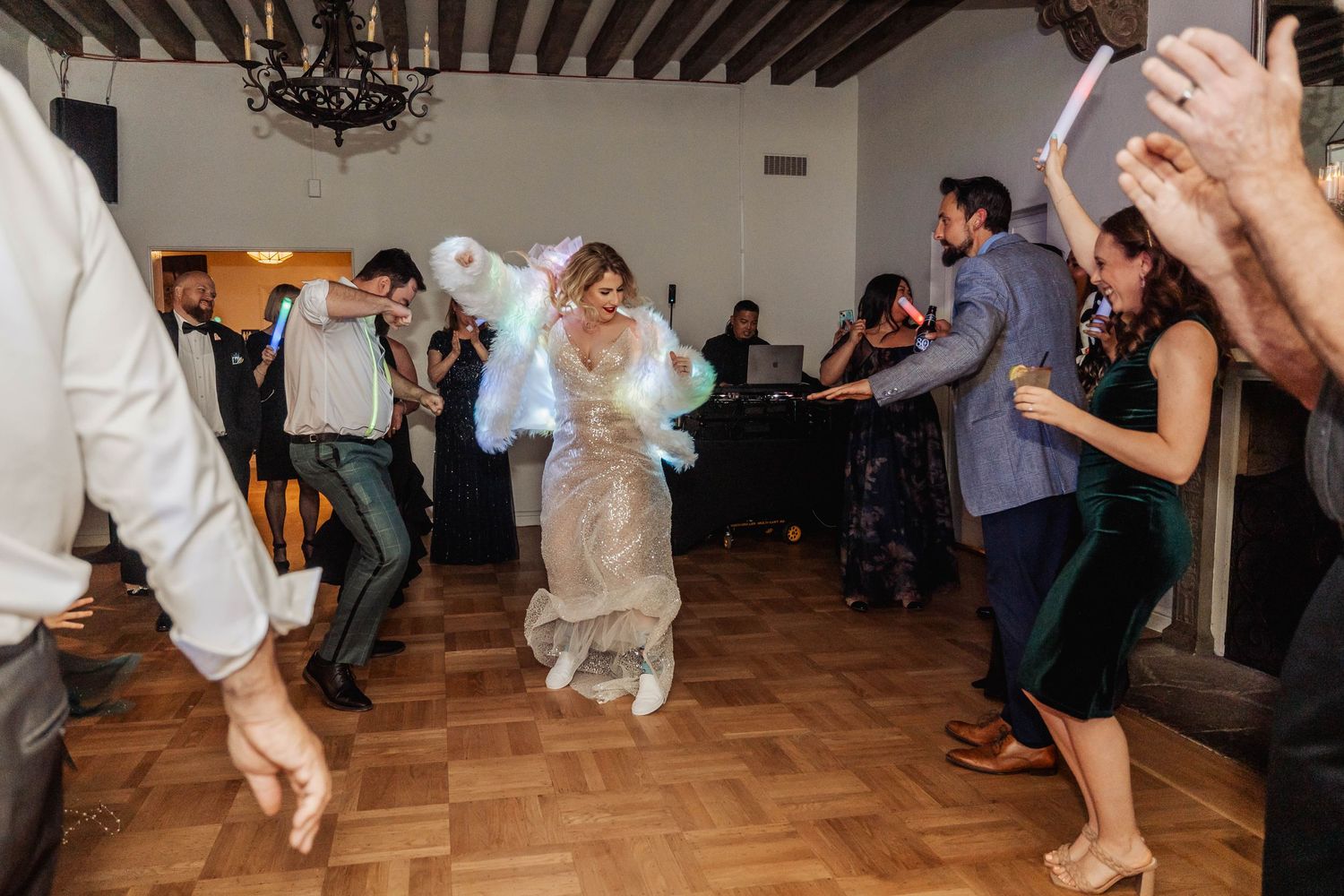 Wedding reception dance floor filled with energetic dancers in motion.