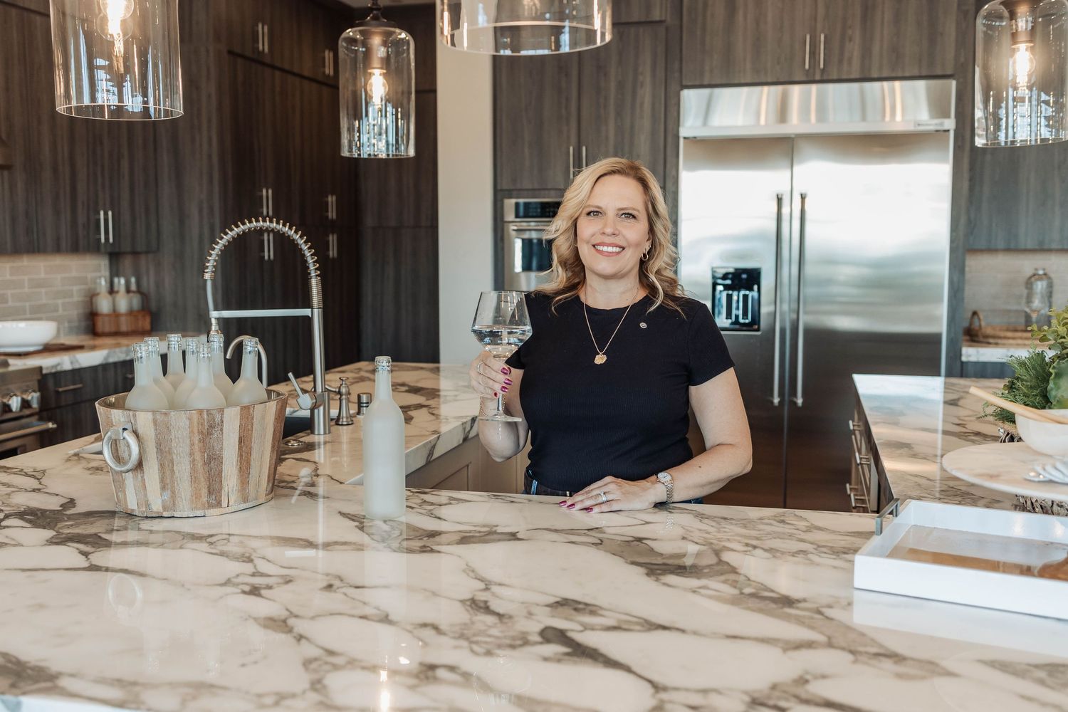 Luxurious kitchen featuring marble countertops and glass pendant lighting.