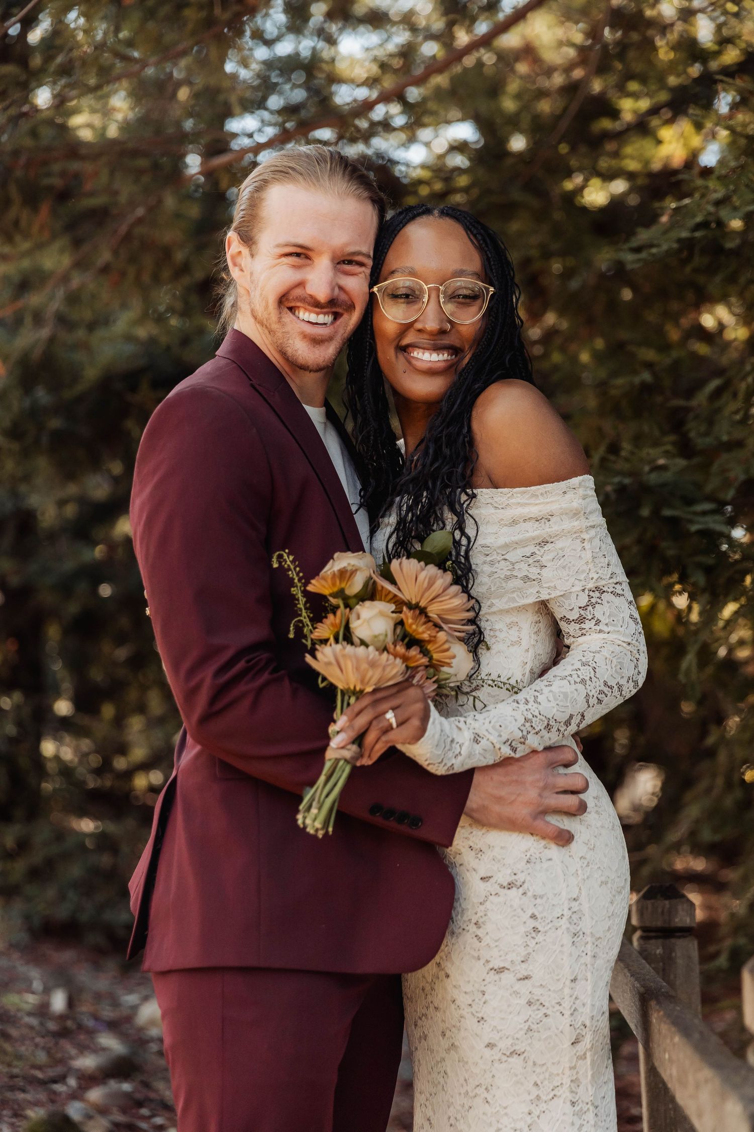 Happy couple embracing outdoors with autumn foliage and sunflowers.