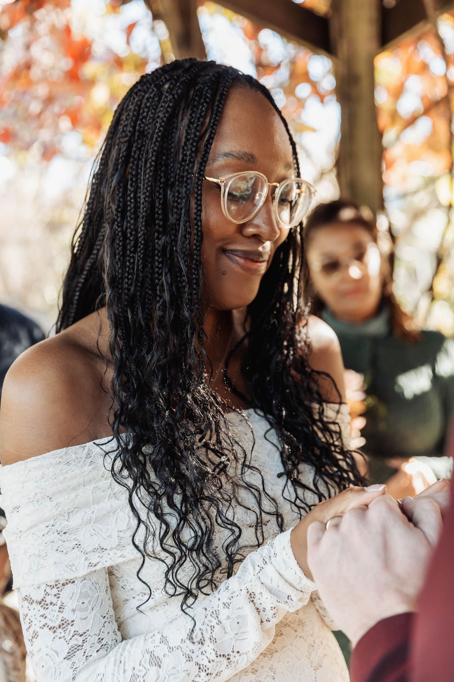 Close-up portrait showing joyful expressions and lace details against an autumn backdrop.