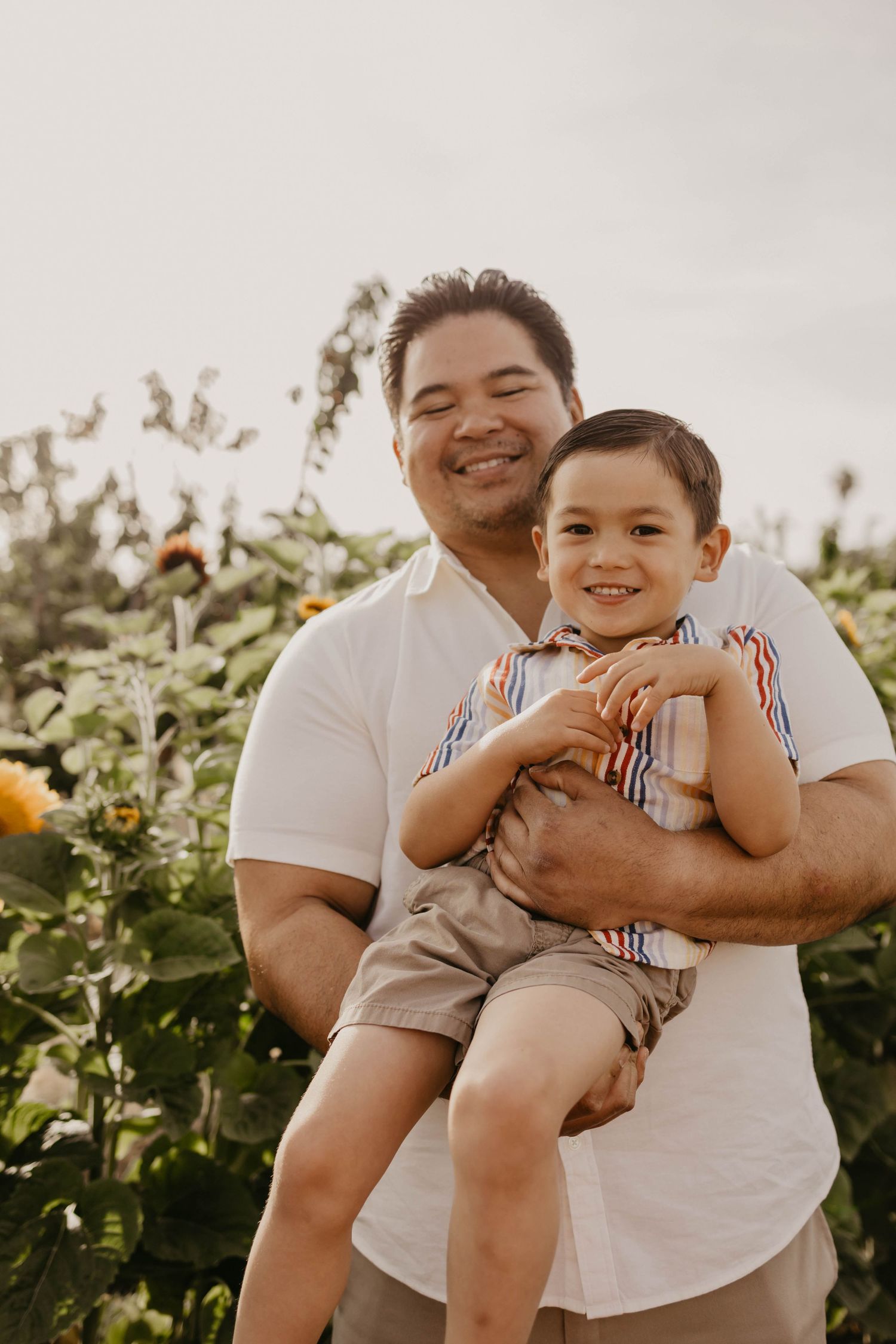 A playful series of photos showing a tender moment in a sunflower field between two people in white tops.