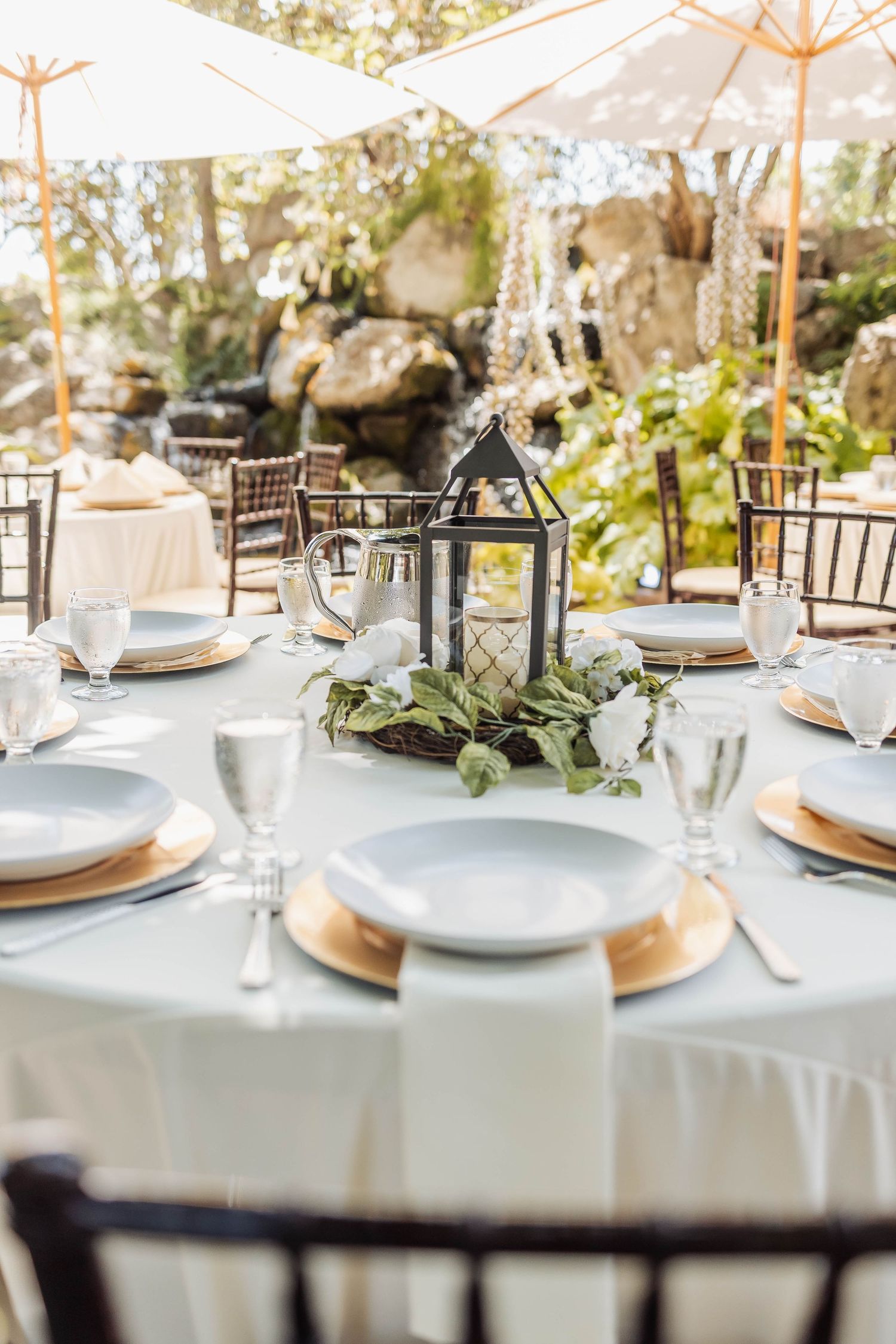 Elegant wedding reception table settings with white linens and floral centerpieces.