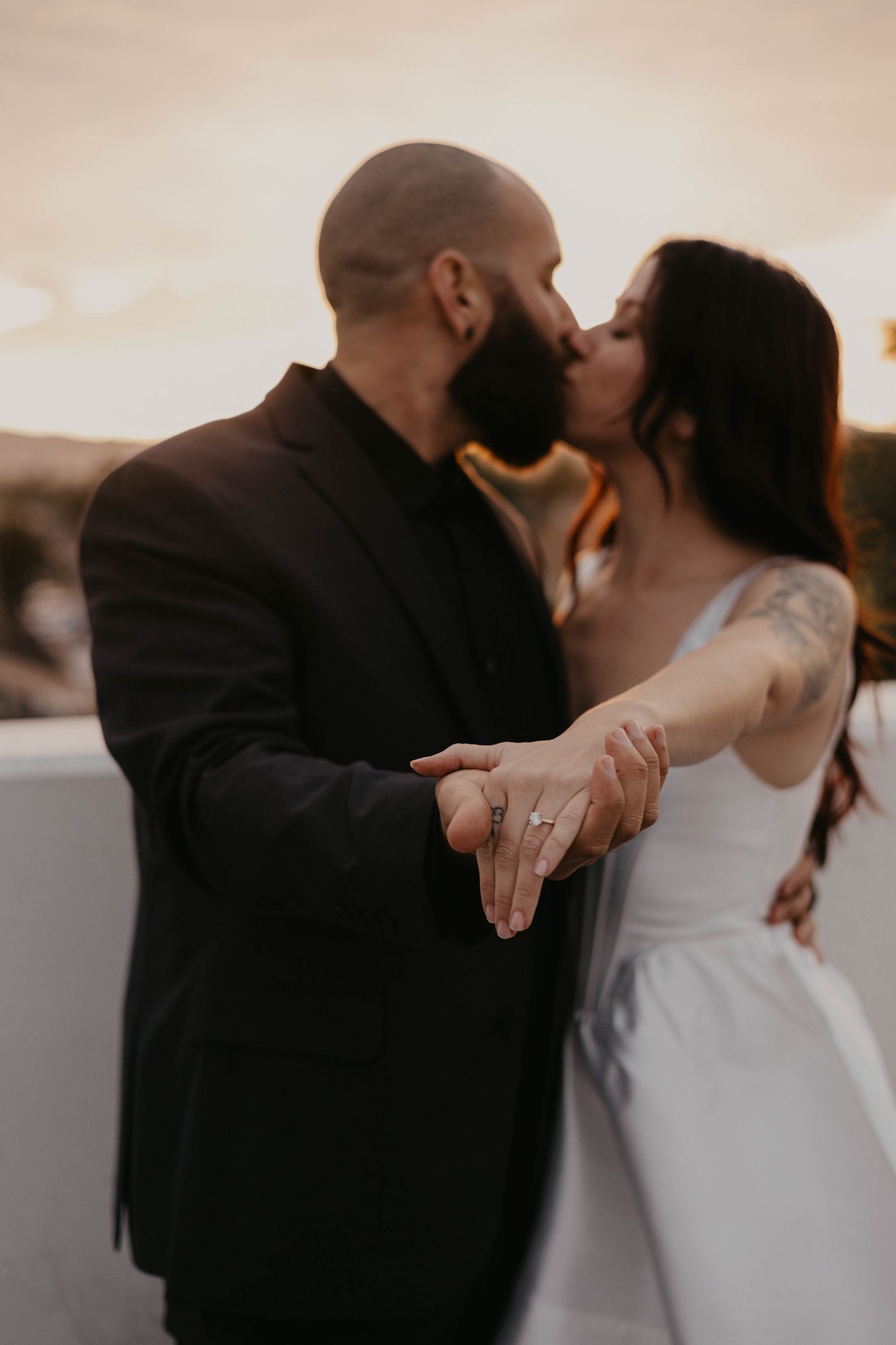 Intimate dancing moment between newlyweds during sunset reception.