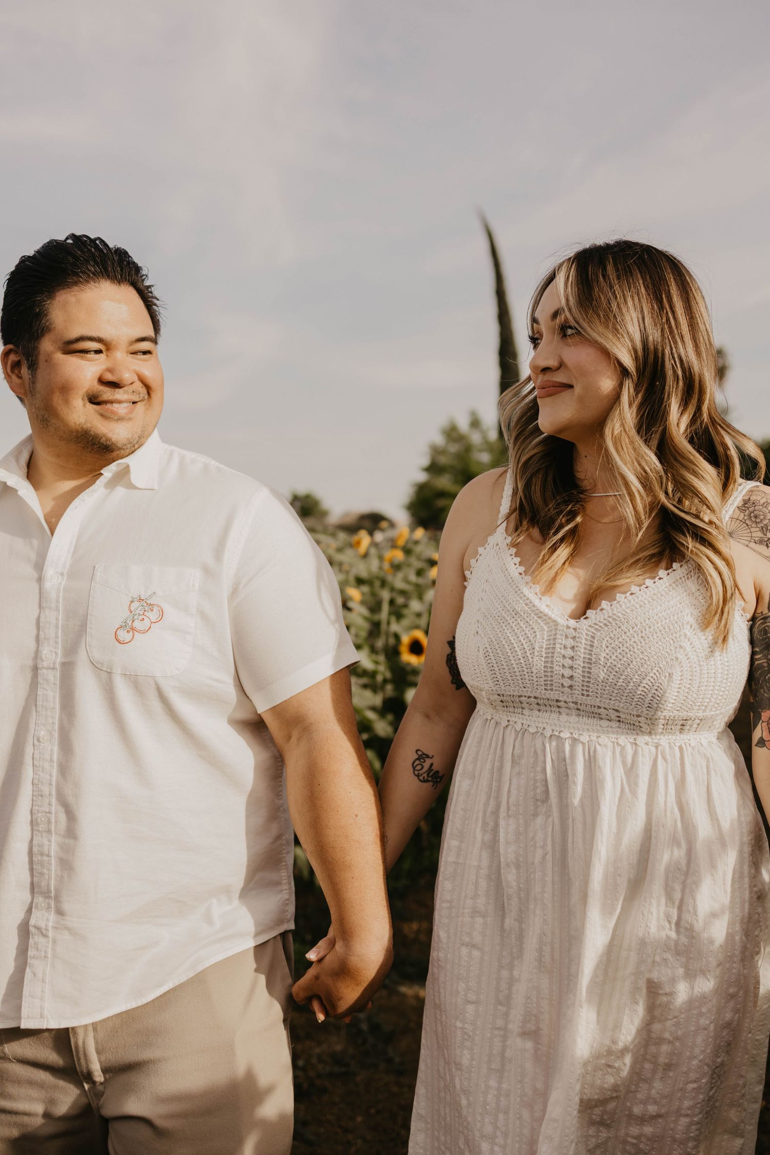 A romantic photoshoot in white outfits against a natural outdoor setting.